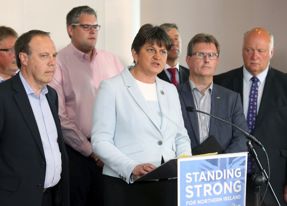 Democratic Unionist Party leader Arlene Foster and speaks to the media, surrounded by her party Members of Parliament, during a press conference at the Stormont hotel in Belfast, Northern Ireland. CREDIT: AP Photo/Peter Morrison