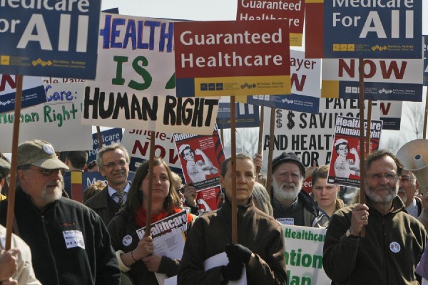 Protesters hold signs at a rally in Burlington, VT. Credit: AP Photo/Toby Talbot