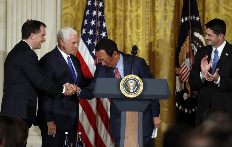 Terry Gou, president and chief executive officer of Foxconn, shakes hands with Wisconsin Gov. Scott Walker, accompanied by Vice President Mike Pence, left, and House Speaker Paul Ryan of Wis., as he speaks in the East Room of the White House, Wednesday, July 26, 2017, in Washington. CREDIT: AP Photo/Alex Brandon