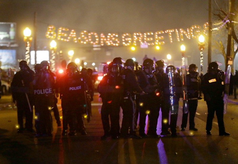 Police gather in the streets of Ferguson, Missouri after a grand jury failed to indict officer Darren Wilson in the shooting death of 18-year-old Michael Brown in 2014. CREDIT: AP Photo/Charlie Riedel