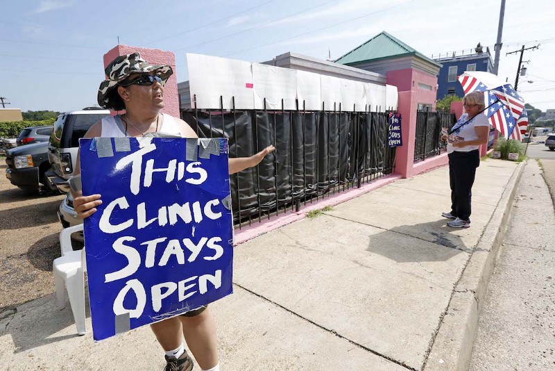 Abortion rights supporter and clinic escort Michelle Colon, left, argues with abortion opponent Mary McLaurin, right, outside the Jackson Women’s Health Organization clinic in Jackson, Miss, August 15, 2013. CREDIT: AP/Rogelio V. Solis