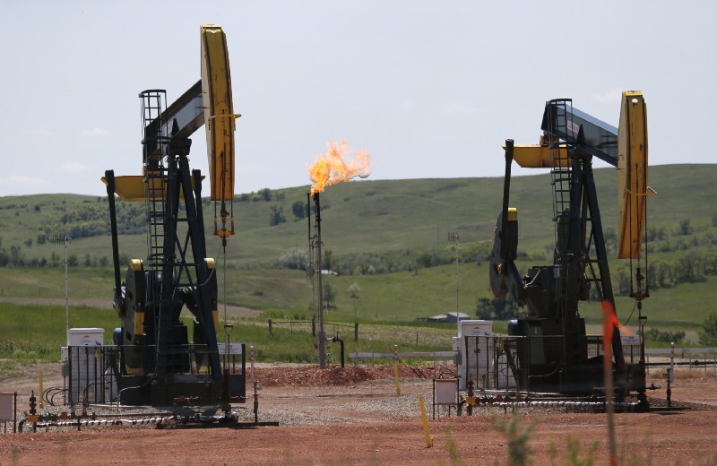 Oil pumps and natural gas burns off in Watford City, North Dakota. CREDIT: AP Photo/Charles Rex Arbogast