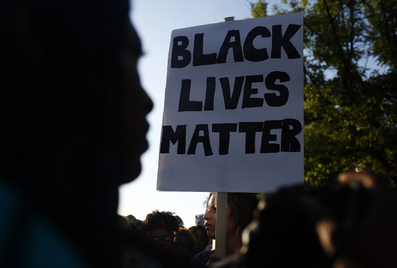 Demonstrators march through downtown Birmingham, Alabama to protest the shootings of two black men by police officers in Minnesota and Louisiana, July 2016. CREDIT: AP Photo/Brynn Anderson