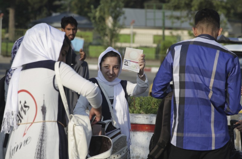 A members of a female robotics team from Herat province, shows her US Visa as she leaves Kabul to the US from Kabul Airport on Friday. The third time’s the charm for Afghanistan’s all girl robotics team, who will be allowed entry into the US to compete in a competition after President Trump personally intervened to reverse a decision twice denying them entry. CREDIT: AP Photos/Massoud Hossaini