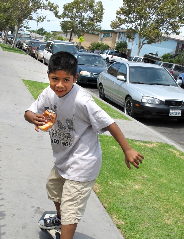 Cesar Gaspar cruises on his skateboard during a Townsend Street community barbecue in Santa Ana, Ca. CREDIT: Yvette Cabrera/ThinkProgress