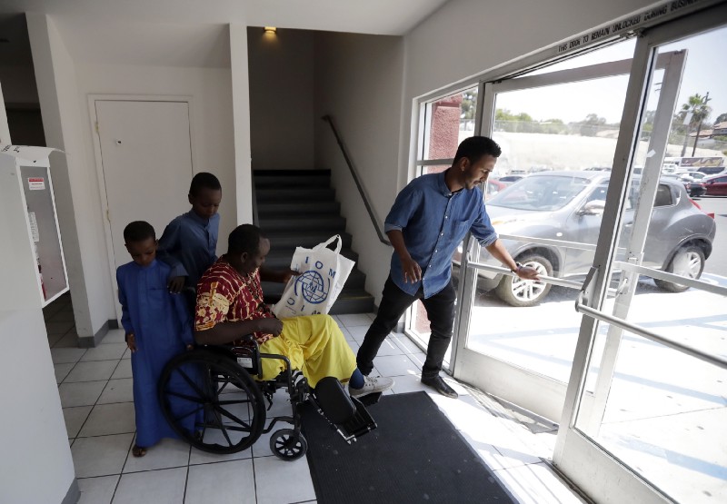 Ali Said, of Somalia, center, leaves a center for refugees with his two sons in San Diego. Said is among the last refugees allowed into the United States before stricter rules kick in as part of the travel ban. CREDIT: AP Photo/Gregory Bull