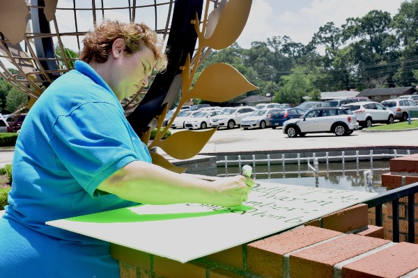 Angela Lorio making a sign outside Living Faith Christian Center, where Senator Cassidy held his town hall. CREDIT: Amanda Gomez/ThinkProgress