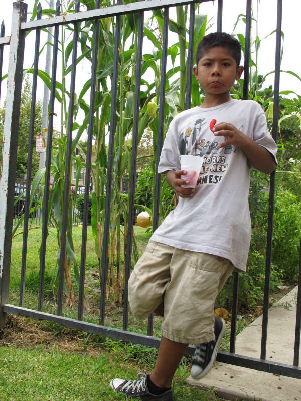 Cesar Gaspar takes a snack break after playing with his friends during a community barbecue on Townsend Street in Santa Ana, Ca. CREDIT: Yvette Cabrera/ThinkProgress