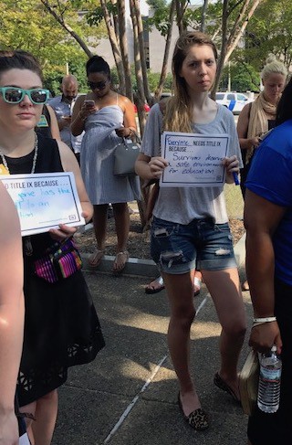 People who attended the event held signs on why they support Title IX. CREDIT: Casey Quinlan