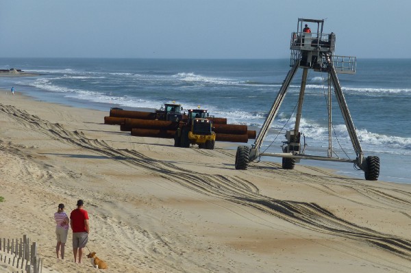 Workers transport pipes used for beach replenishment in Duck, North Carolina. CREDIT: Mark Hand/ThinkProgress