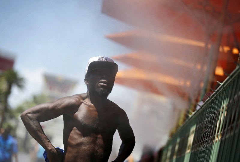 A man cools off in a mist of water along Las Vegas Boulevard in Las Vegas, Nevada. CREDIT: AP Photo/John Locher