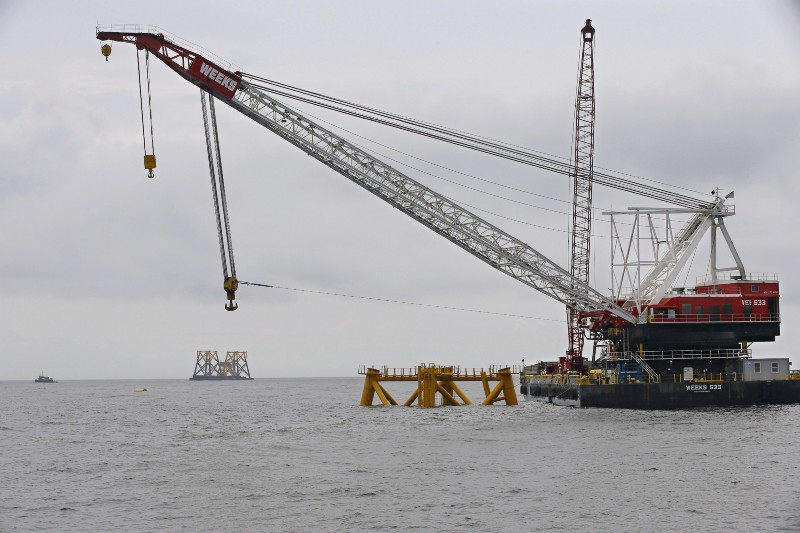 The first foundation jacket installed by Deepwater Wind in the nation’s first offshore wind farm construction project is seen next to a floating construction crane on the waters of the Atlantic Ocean off Block Island, R.I. CREDIT: AP Photo/Stephan Savoia