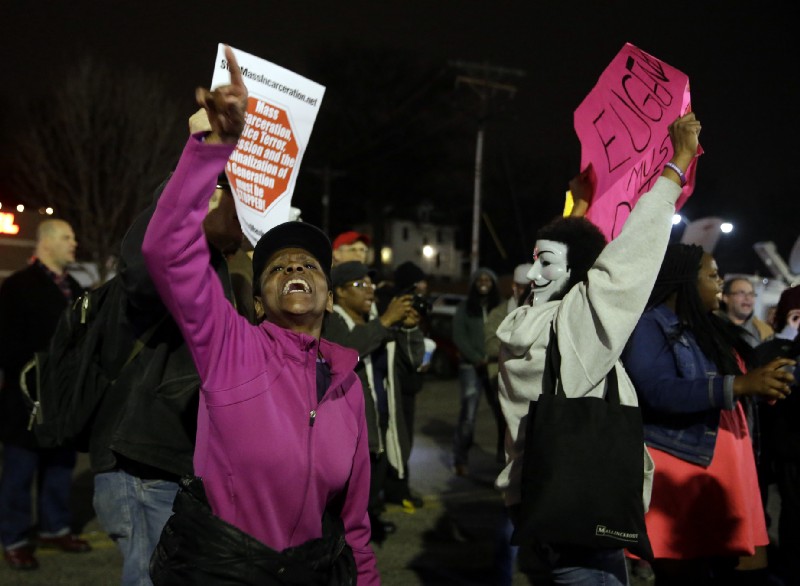 People demonstrate across the street from the Ferguson Police Department, Thursday, March 12, 2015, in Ferguson, Mo. CREDIT: AP Photo/Jeff Roberson