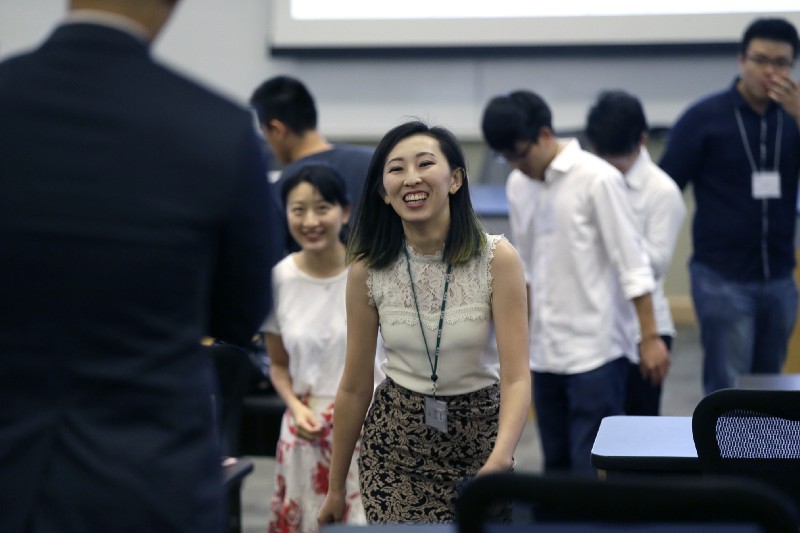In this photo made Saturday, Aug. 22, 2015, Hua Bai, center, vice president of Friendship Association of Chinese Scholars and Students, laughs as she prepares for an orientation for fellow Chinese students at the University of Texas at Dallas in Richardson, Texas. The 25-year-old said at the time that given the right opportunity, she’d like to stay in the U.S.; CREDIT: AP Photo/LM Otero