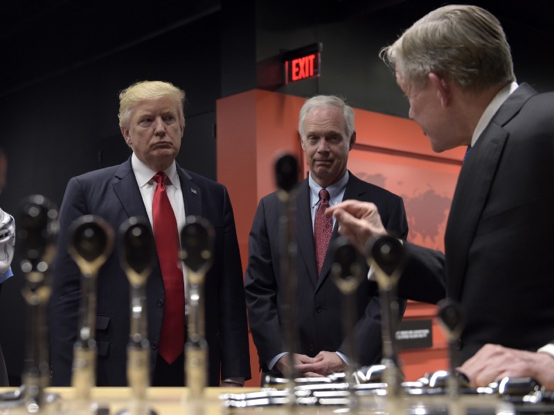 President Donald Trump and Sen. Ron Johnson, R-Wis., center, listens as Snap-on Inc., Chief Executive Officer Nicholas T. Pinchuk, speaks during a tour of the company headquarters in Kenosha, Wis., Tuesday, April 18, 2017. Trump visited the headquarters of tool manufacturer Snap-on Inc., and will later signed an executive order that seeks to make changes to a visa program that brings in high-skilled workers. (AP Photo/Susan Walsh)