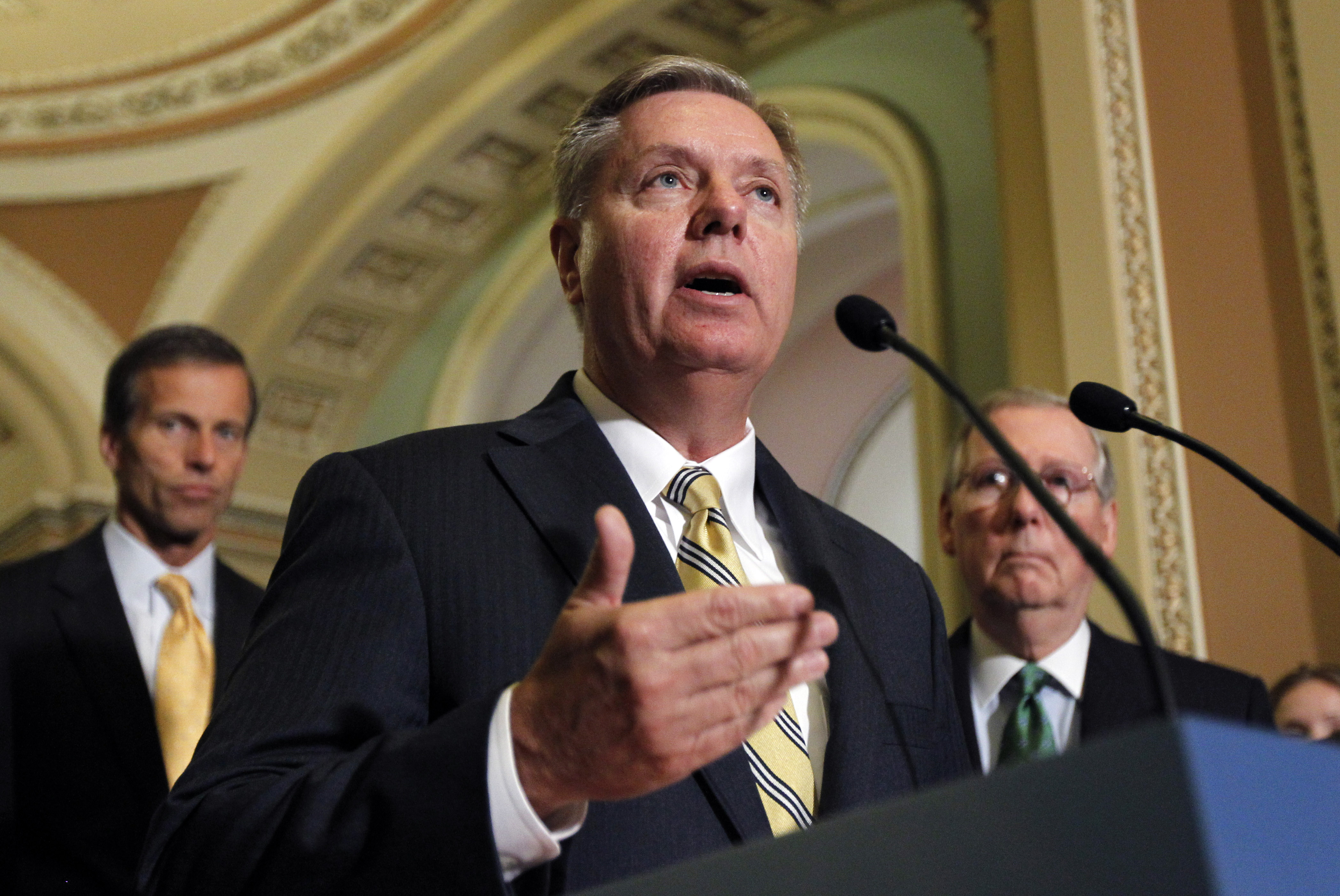 Sen. John Thune, R-S.D., left, and Senate Minority Leader Mitch McConnell, of Kentucky, right, stand as Sen. Lindsey Graham, R-S.C., speaks to the media after their caucus luncheon on Capitol Hill Tuesday, June 14, 2011 in Washington. CREDIT: AP Photo/Alex Brandon