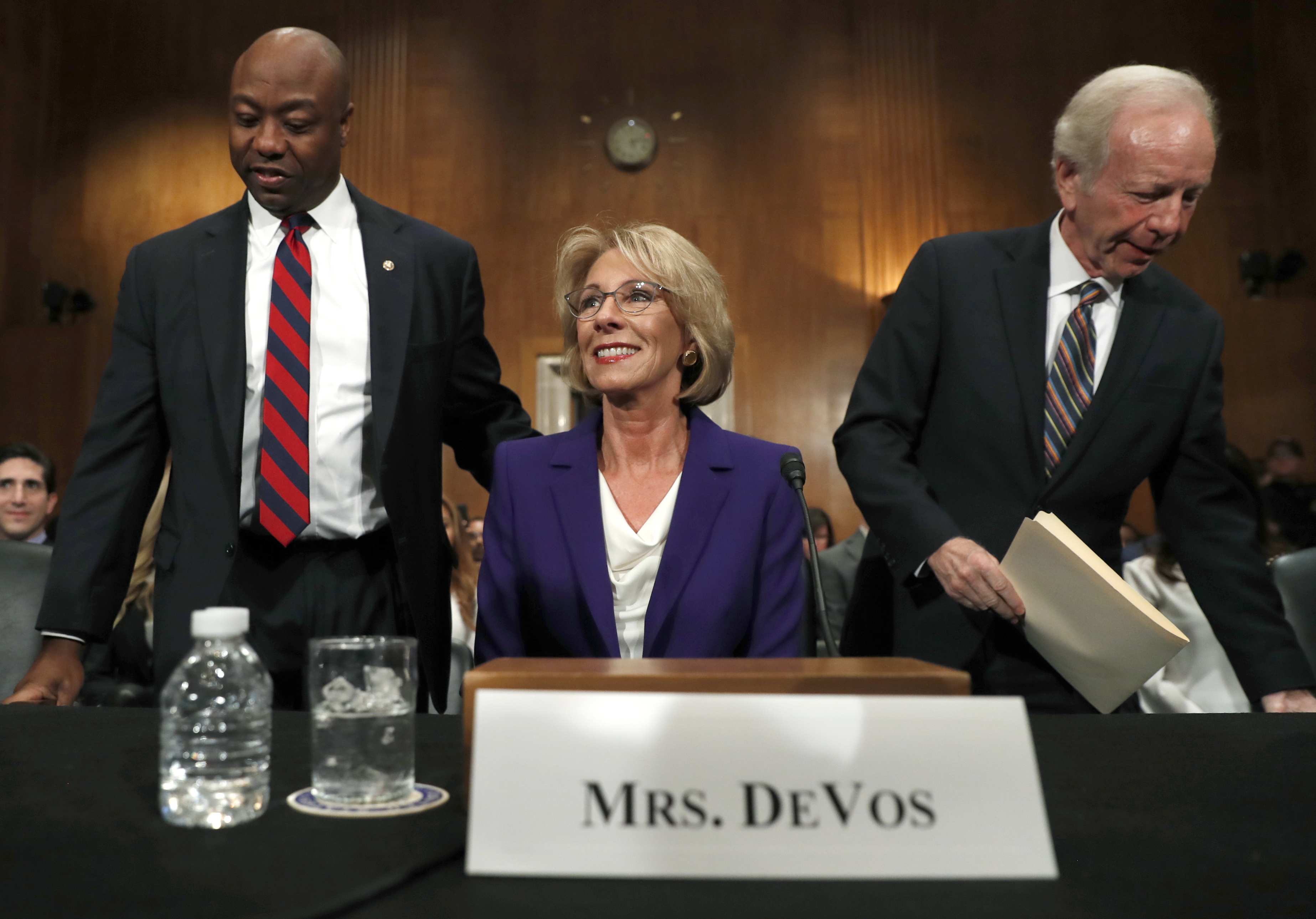 Sen. Tim Scott (R-SC) and former Sen. Joe Lieberman (D-CT) sit down to introduce Education Secretary Betsy DeVos at a January hearing regarding her nomination to the job. CREDIT: AP Photo/Carolyn Kaster