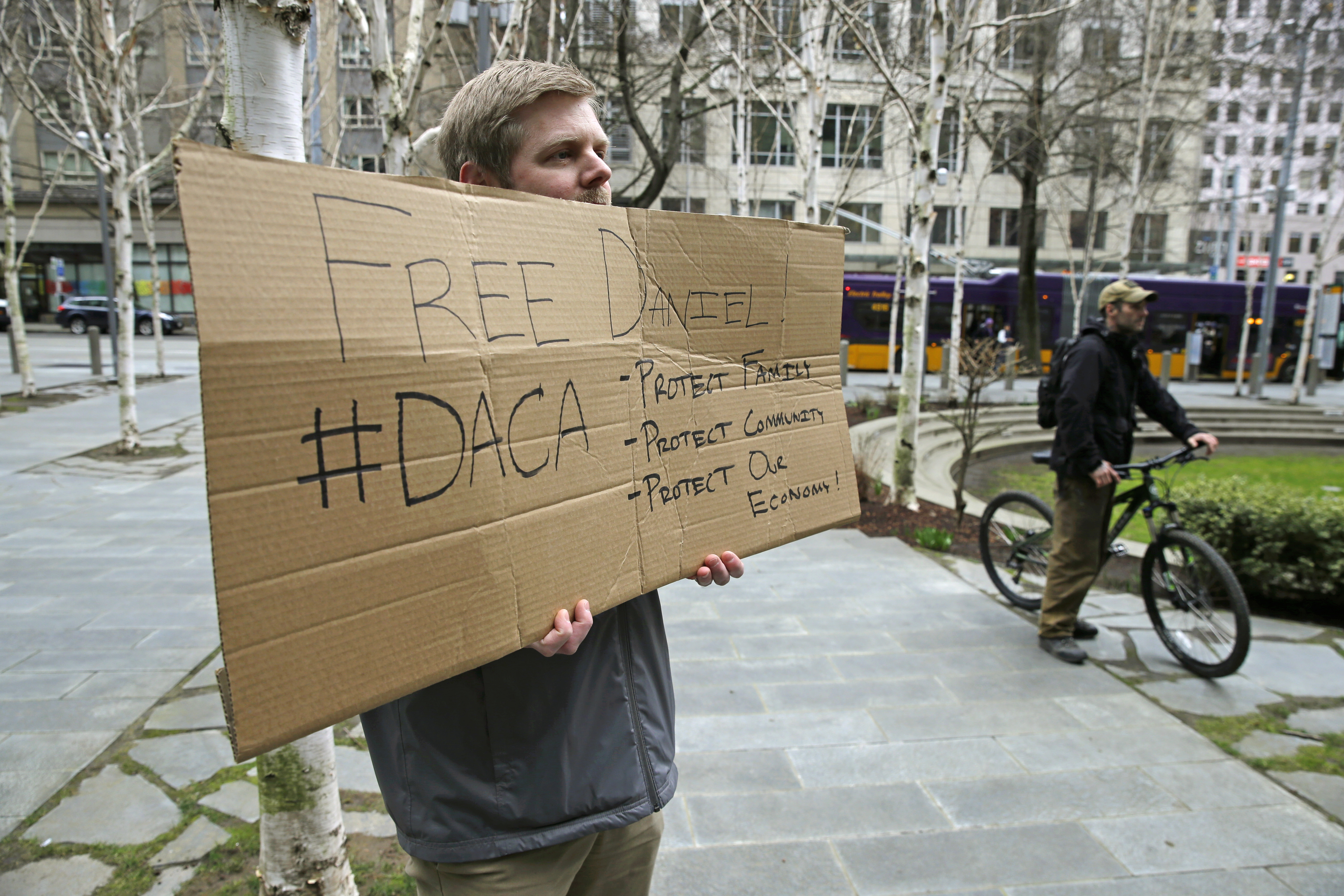 Bard Luippold, of Tacoma, Wash., holds a sign in support of Daniel Ramirez Medina, Wednesday, March 8, 2017, outside the federal courthouse in Seattle. Luippold, who called himself a "citizen ally" for Medina and other immigrants protected by the Deferred Action for Childhood Arrivals program, attended a hearing Wednesday for Medina, a Seattle-area man who was arrested in February and detained by immigration agents despite his participation in a federal program to protect those brought to the U.S. illegally as children. A federal magistrate said Wednesday that he expects to rule early next week on whether to release Medina. (AP Photo/Ted S. Warren)