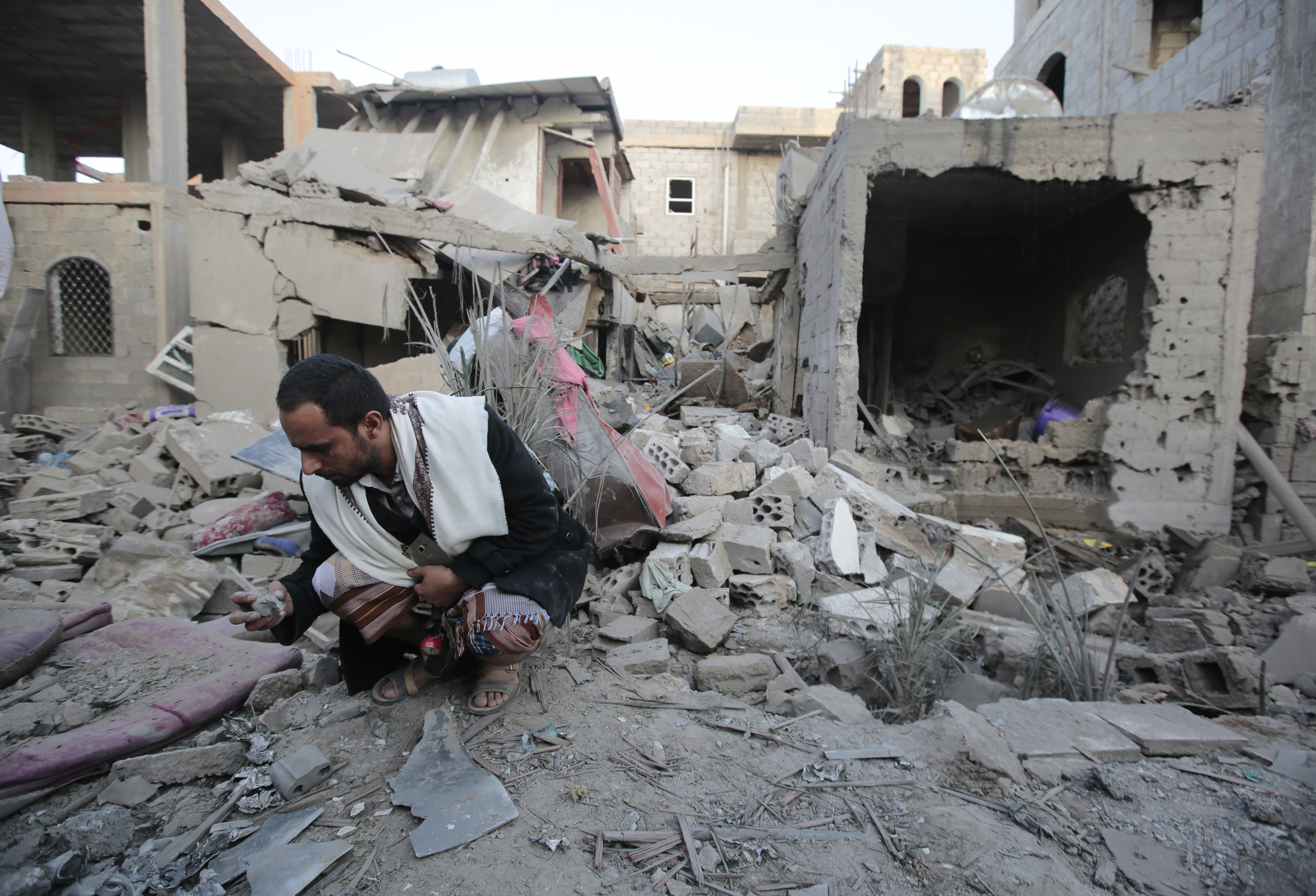 A man holds debris from the rubble of houses destroyed by Saudi-led airstrikes in Sanaa, Yemen, CREDIT: (AP Photo/Hani Mohammed
