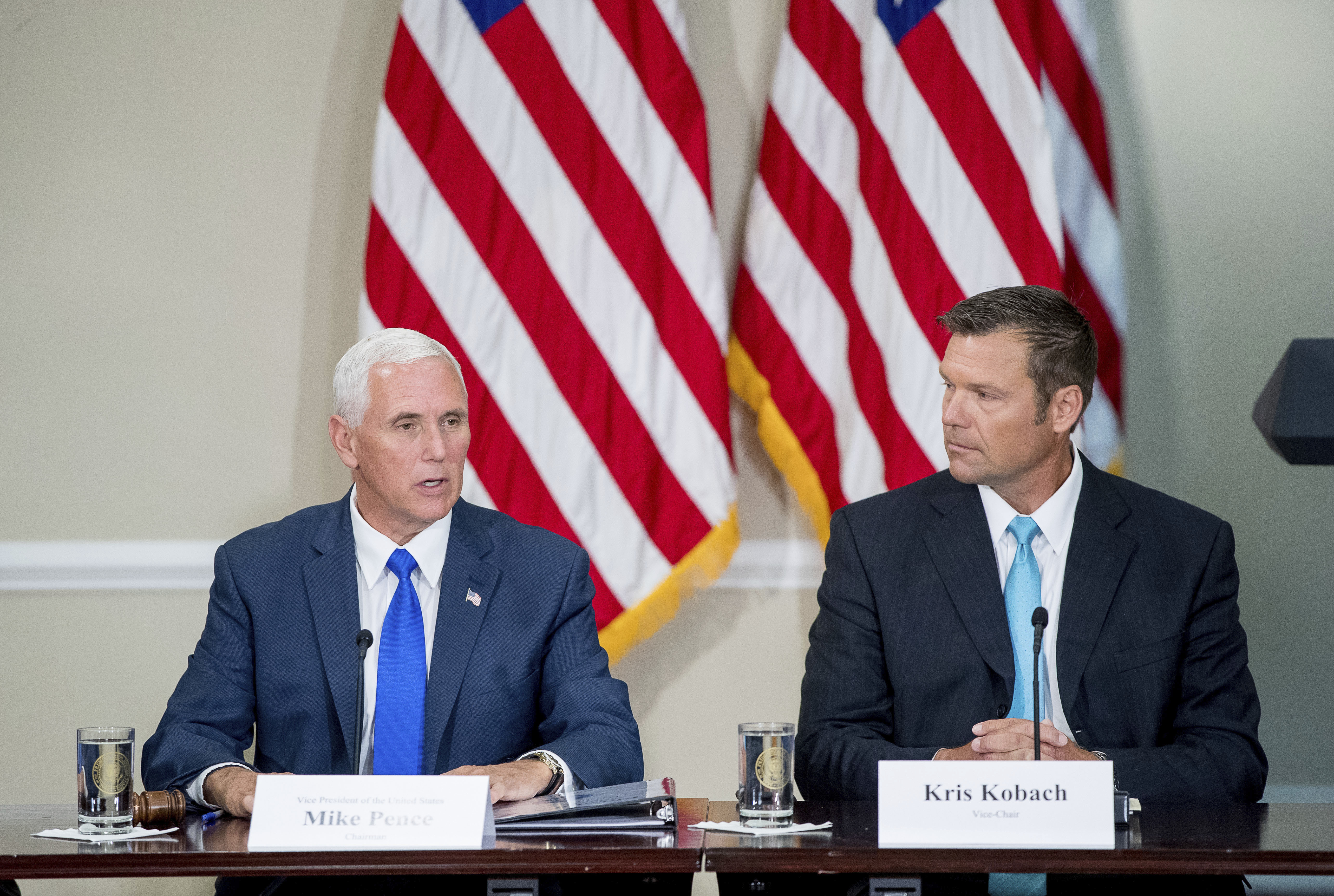 Vice President Mike Pence, left, accompanied by Vice-Char Kansas Secretary of State Kris Kobach, right, speaks during the first meeting of the Presidential Advisory Commission on Election Integrity at the Eisenhower Executive Office Building on the White House complex in Washington, Wednesday, July 19, 2017. CREDIT: AP Photo/Andrew Harnik