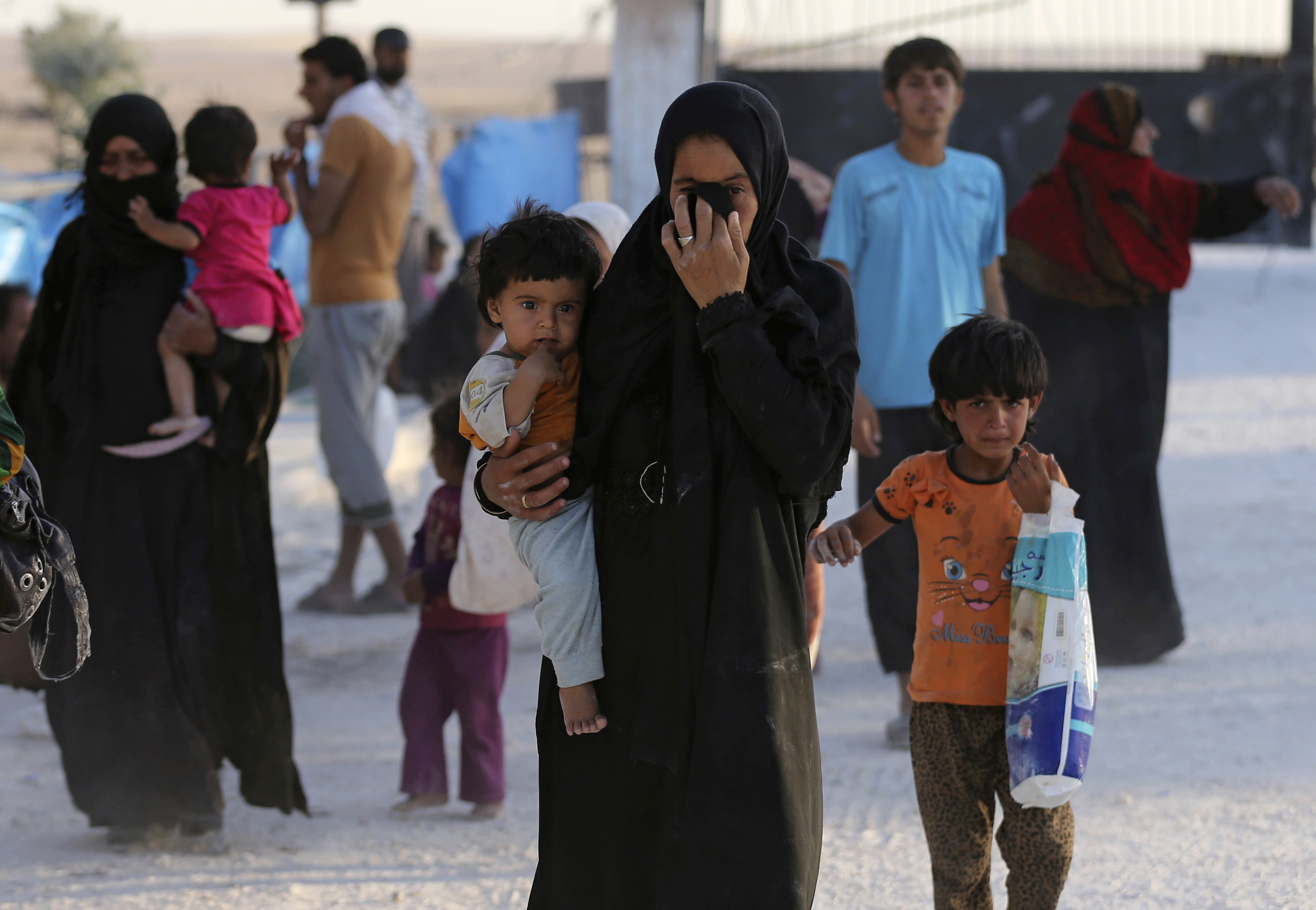 A Syrian family who fled the battle between U.S.-backed Syrian Democratic Forces (SDF) and the Islamic State militants from Raqqa city, arrive at a refugee camp, in Ain Issa town, northeast Syria, Monday, July 24, 2017. CREDIT: AP Photo/Hussein Malla