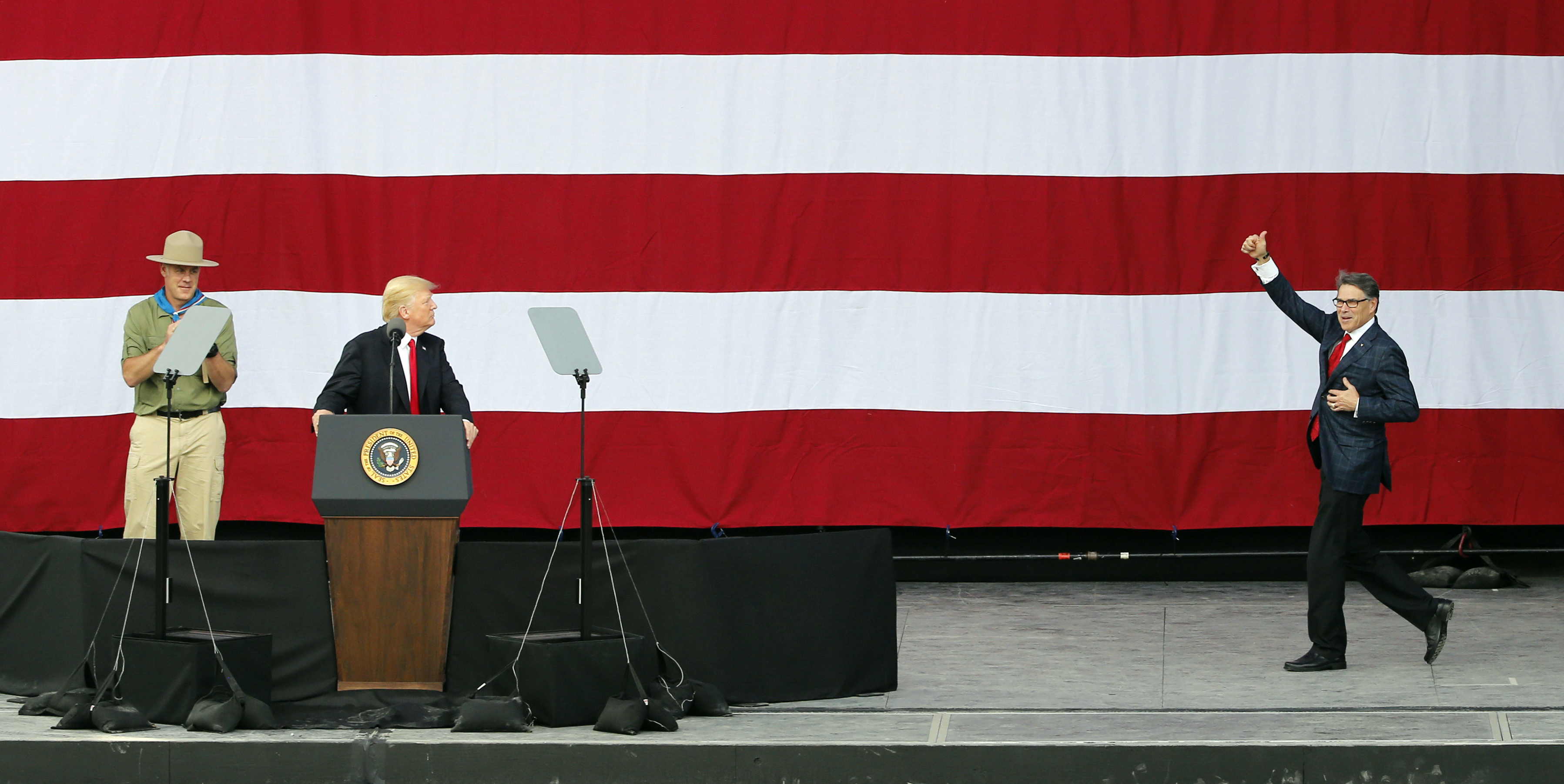 President Donald Trump welcomes Energy Secretary Rick Perry to the stage in July. CREDIT: AP Photo/Steve Helber