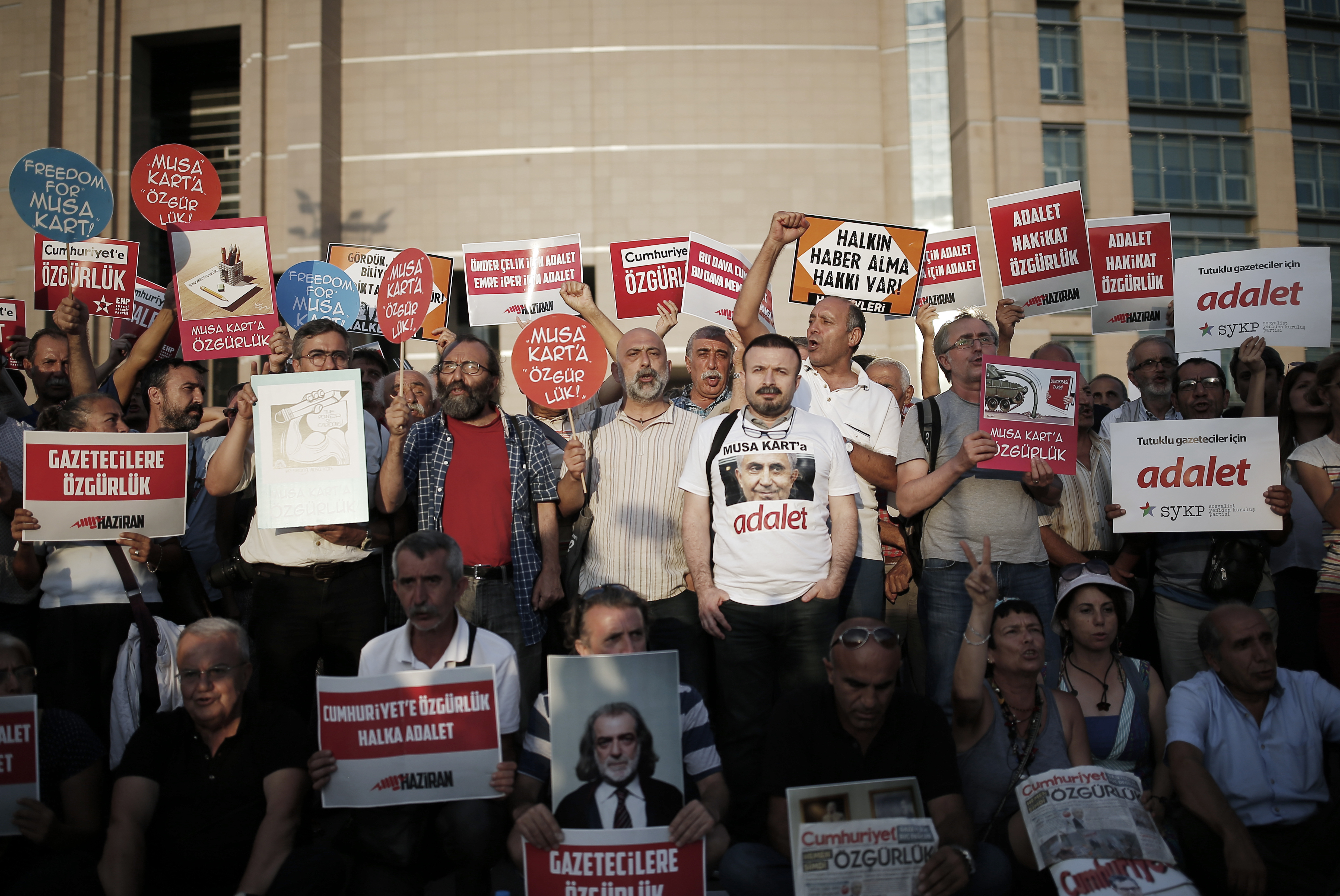 Journalists and activists gather outside the court in Istanbul, Friday, July 28, 2017, protesting against the trial of journalists and staff from the Cumhuriyet newspaper, staunchly opposed to President Recep Tayyip Erdogan, accused of aiding terror organizations. CREDIT: AP Photo/Emrah Gurel