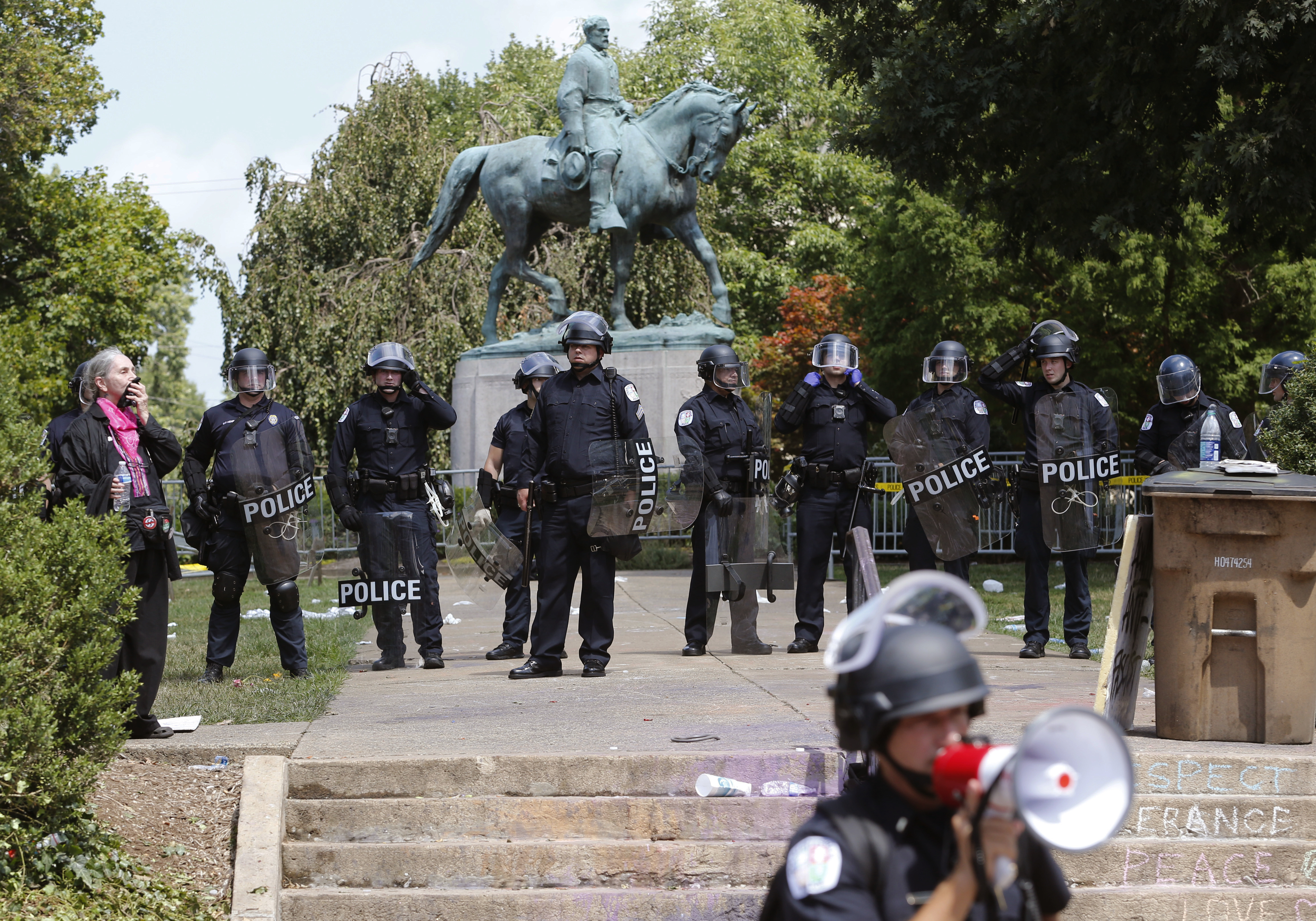 State Police in riot gear guard Lee Park after a white nationalist demonstration was declared illegal and the park was cleared in Charlottesville, Va., Saturday, Aug. 12. Hundreds of people chanted, threw punches, hurled water bottles, and unleashed chemical sprays on each other Saturday after violence erupted at the white nationalist rally. (AP Photo/Steve Helber)