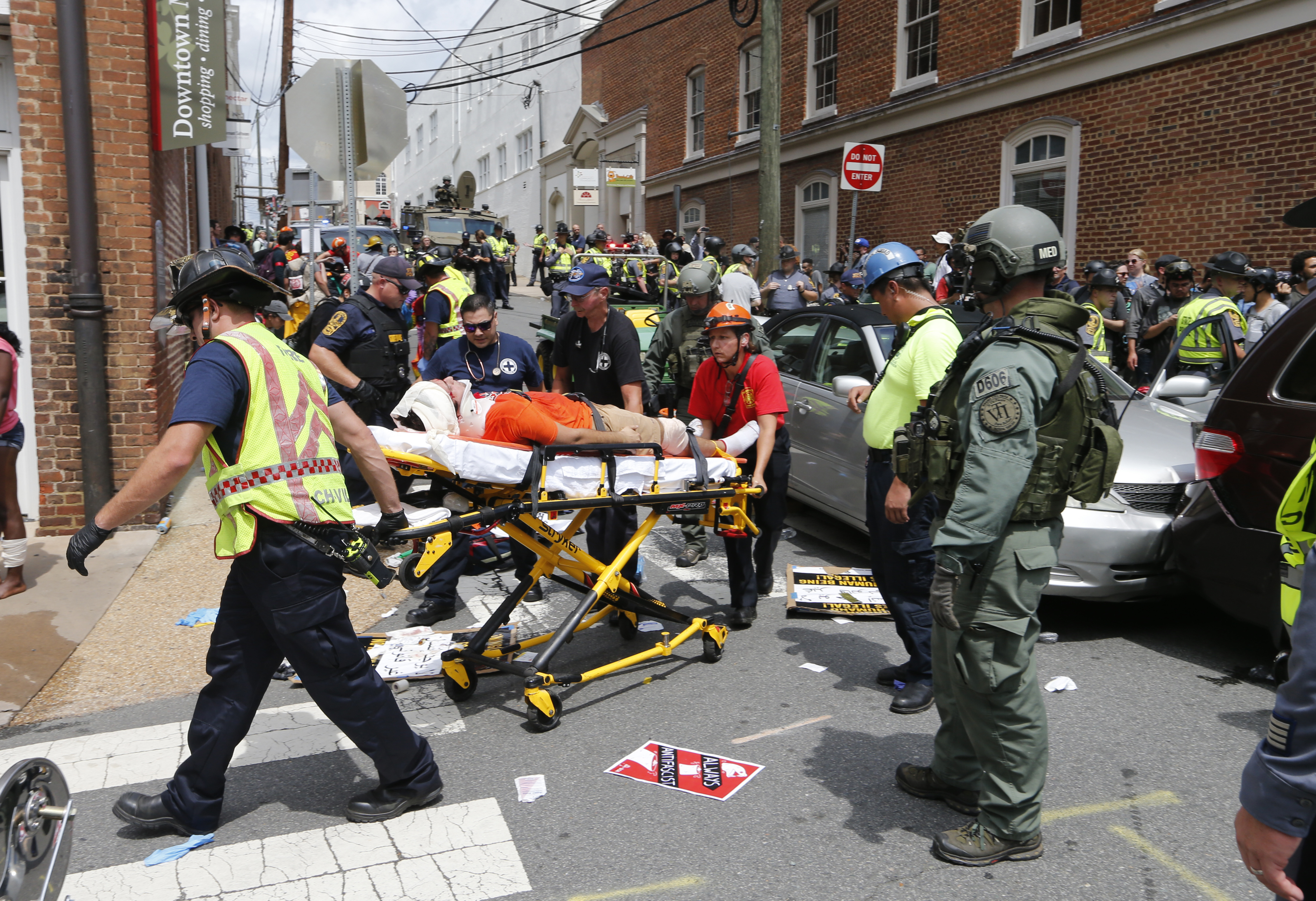 Rescue personnel help injured people after a car ran into a large group of protesters after an white nationalist rally in Charlottesville, Va., Saturday, Aug. 12, 2017. CREDIT: AP Photo/Steve Helber