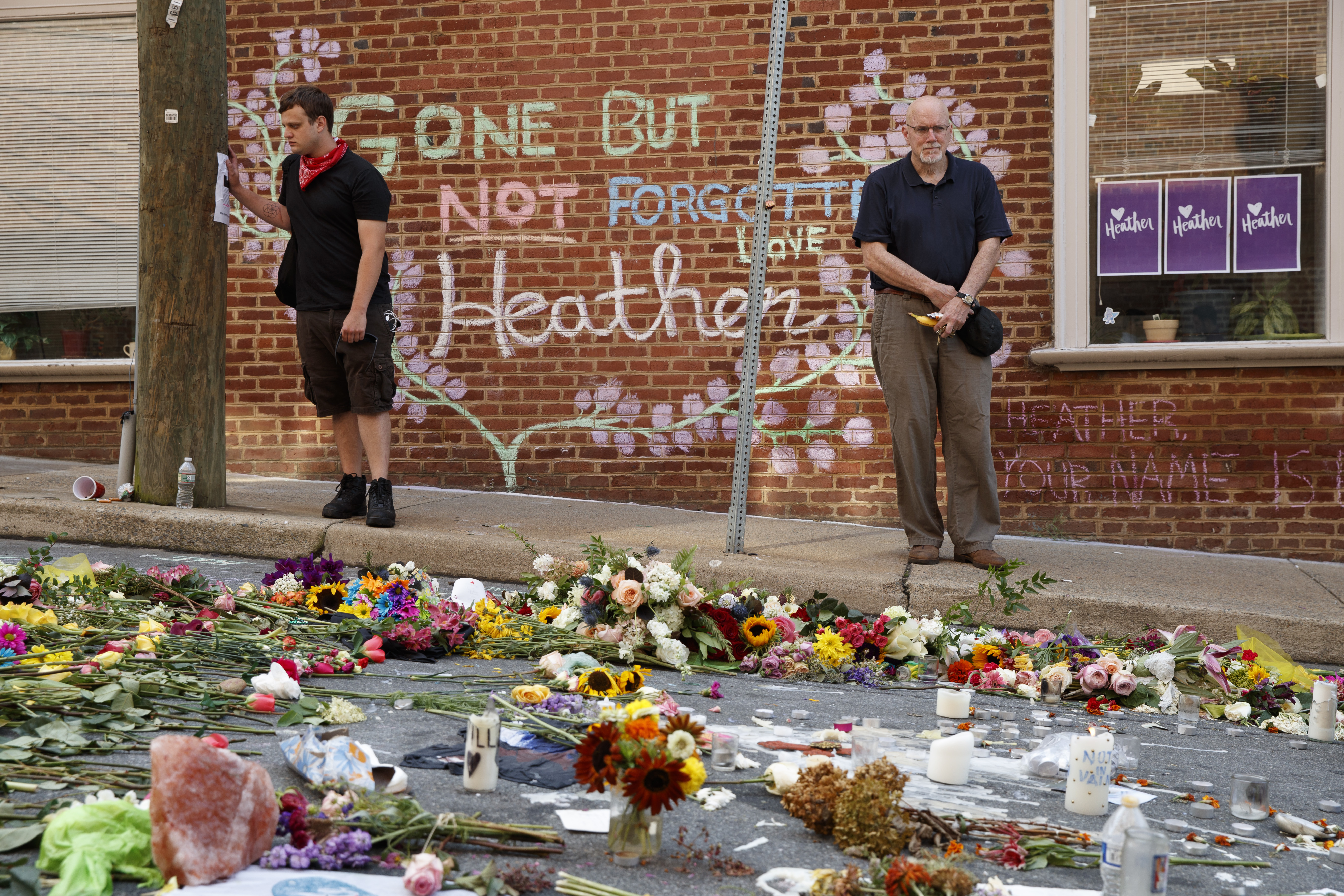 Jason Charter of Washington, left, stands at the site where Heather Heyer was killed during a white nationalist rally, Wednesday, Aug. 16, 2017, in Charlottesville, Va. Charter was at the scene when a car rammed into a crowd of people protesting the rally. CREDIT: AP Photo/Evan Vucci