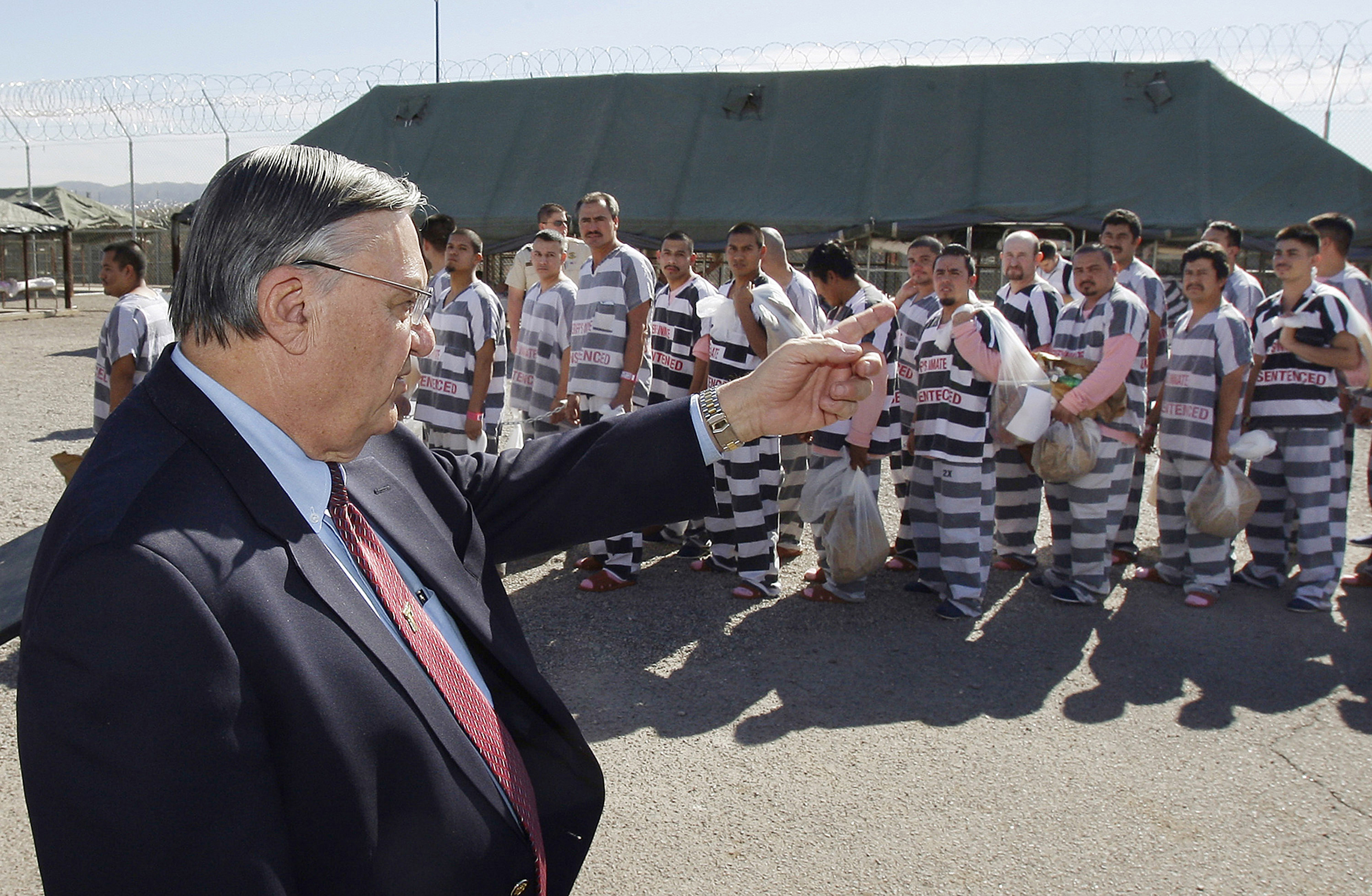 In this Feb. 4, 2009, file photo, Maricopa County Sheriff Joe Arpaio, left, orders approximately 200 convicted illegal immigrants handcuffed together and moved into a separate area of Tent City, for incarceration until their sentences are served and they are deported to their home countries, in Phoenix. CREDIT: AP Photo/Ross D. Franklin, File