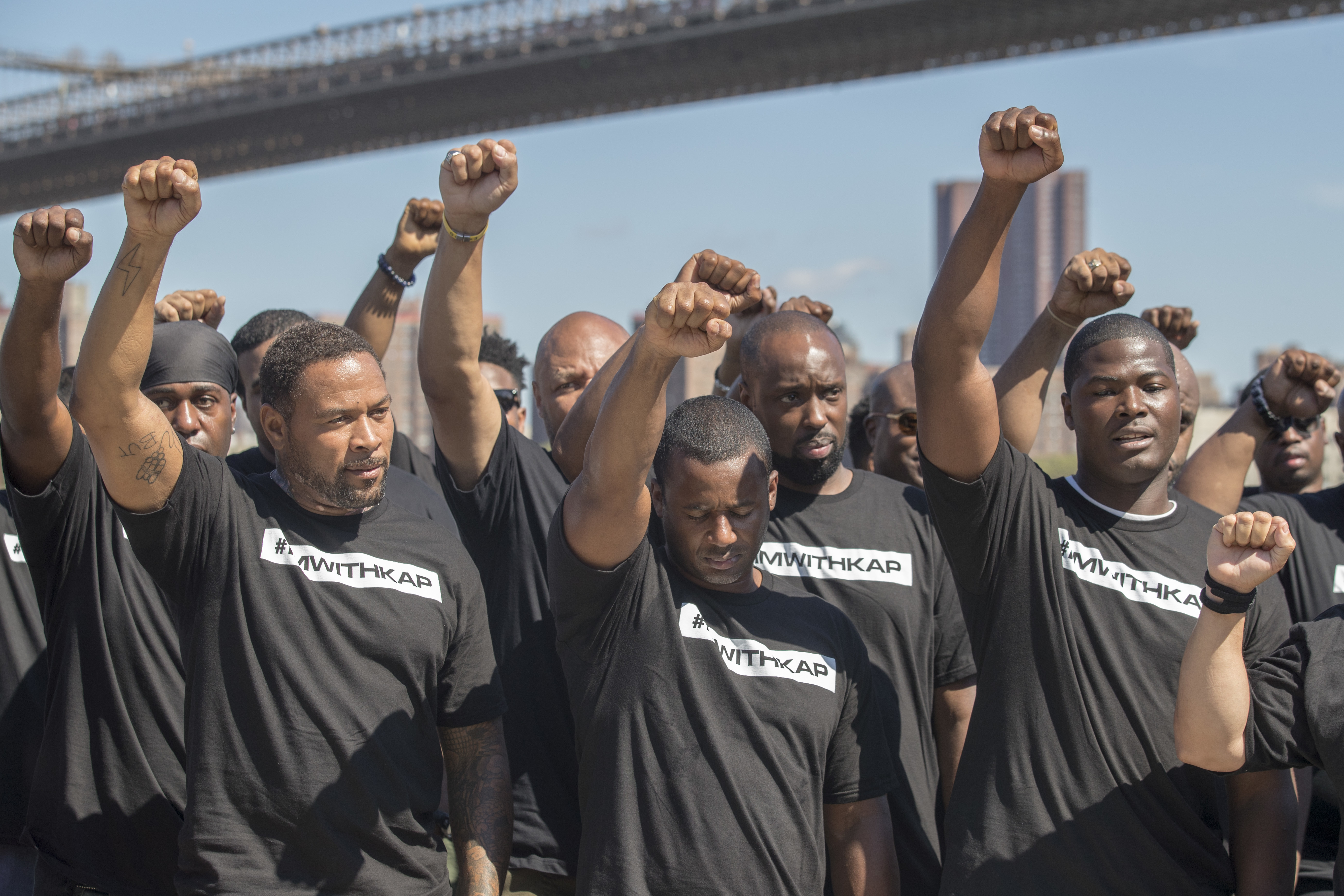 Members of law enforcement raise their fists during a rally to show support for Colin Kaepernick, Saturday, Aug. 19, 2017, in New York. Kaepernick, the former quarterback for the San Francisco 49ers, became a controversial figure last year after he refused to stand for the national anthem. He said it was a protest against oppression of black people. (AP Photo/Mary Altaffer)
