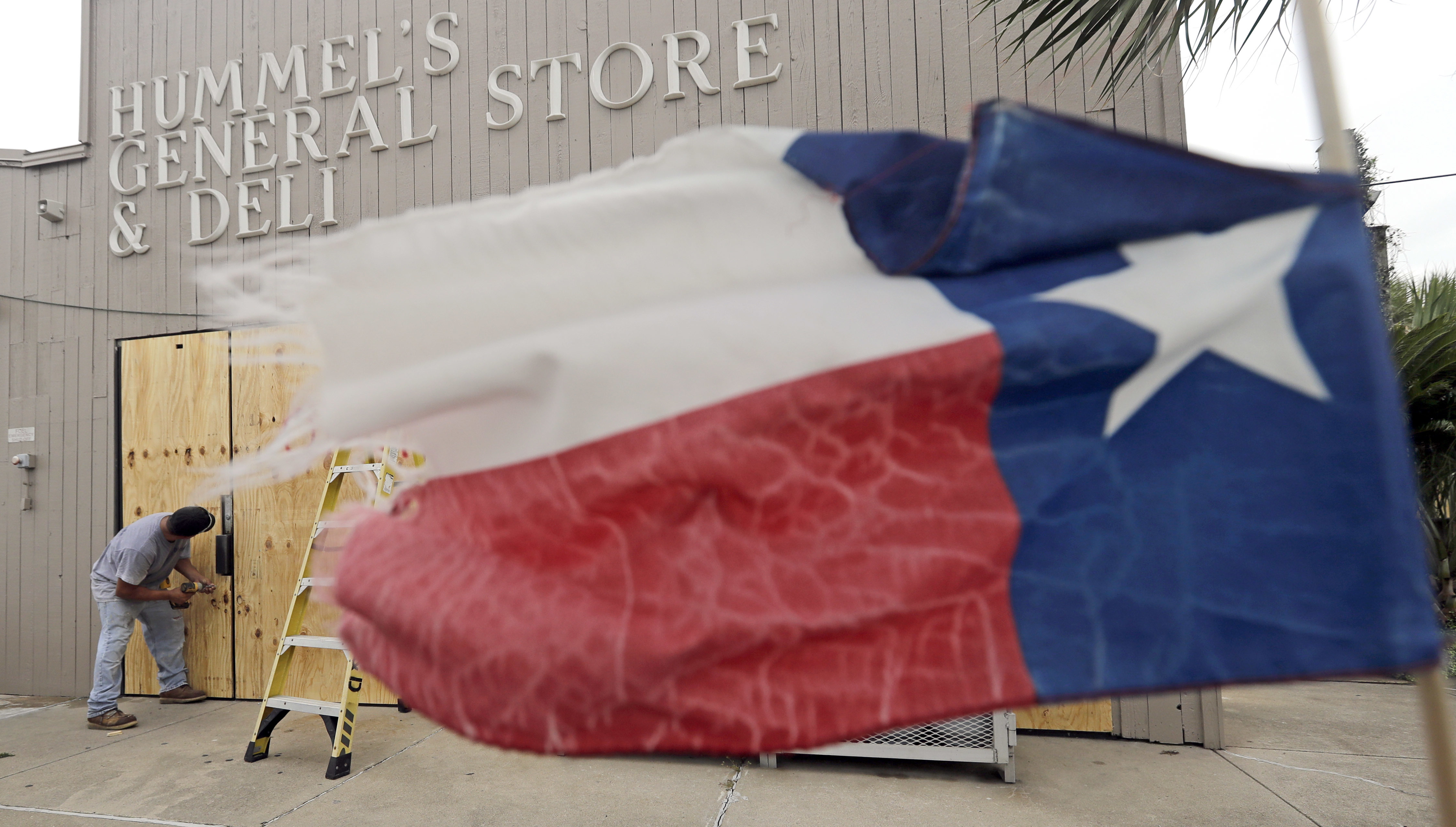 Ramon Lopez boards up windows of a business in Galveston, Texas as Hurricane Harvey intensifies in the Gulf of Mexico Friday, Aug. 25, 2017. Harvey is forecast to be a major hurricane when it makes landfall along the middle Texas coastline. CREDIT: AP Photo/David J. Phillip