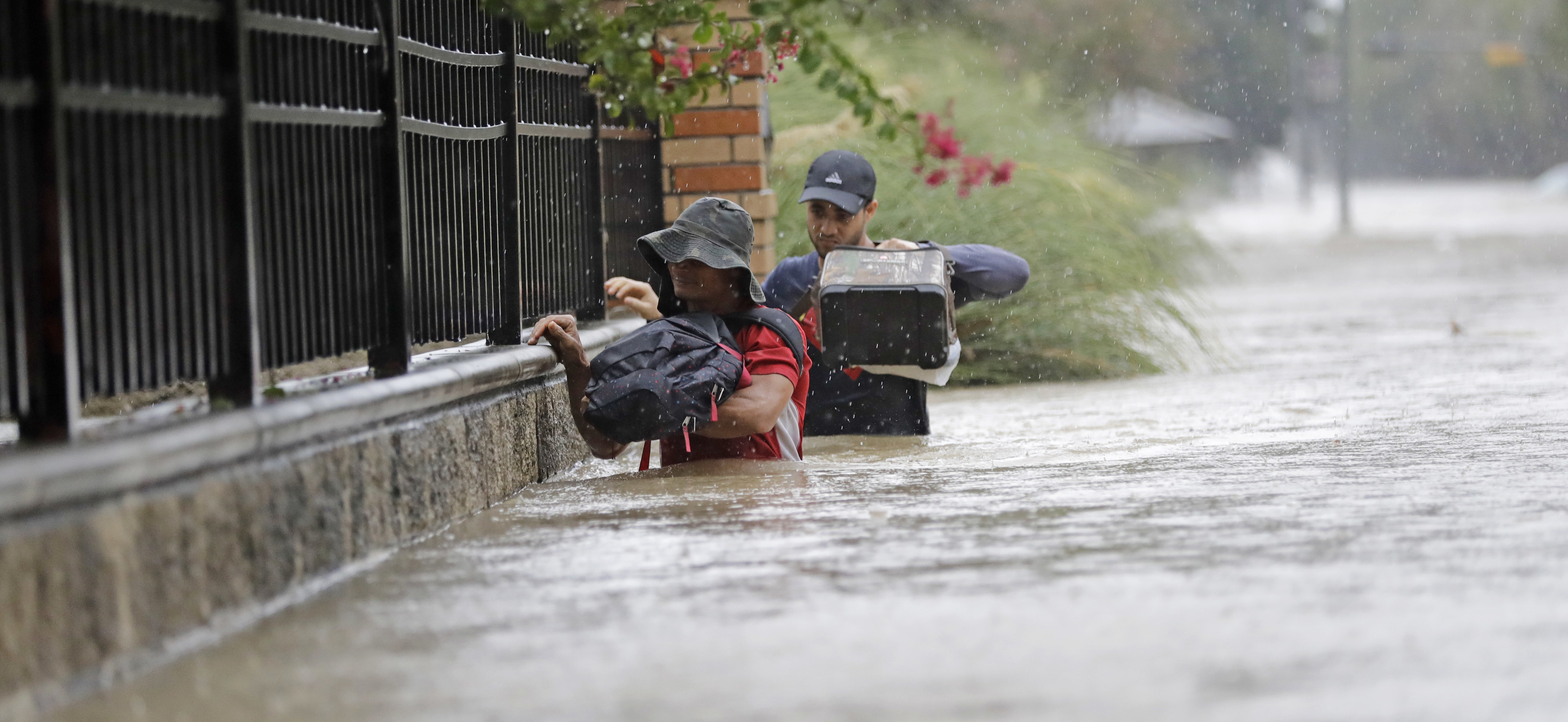Residents wade through floodwaters from Tropical Storm Harvey Sunday, Aug. 27, 2017, in Houston, Texas. CREDIT: AP Photo/David J. Phillip