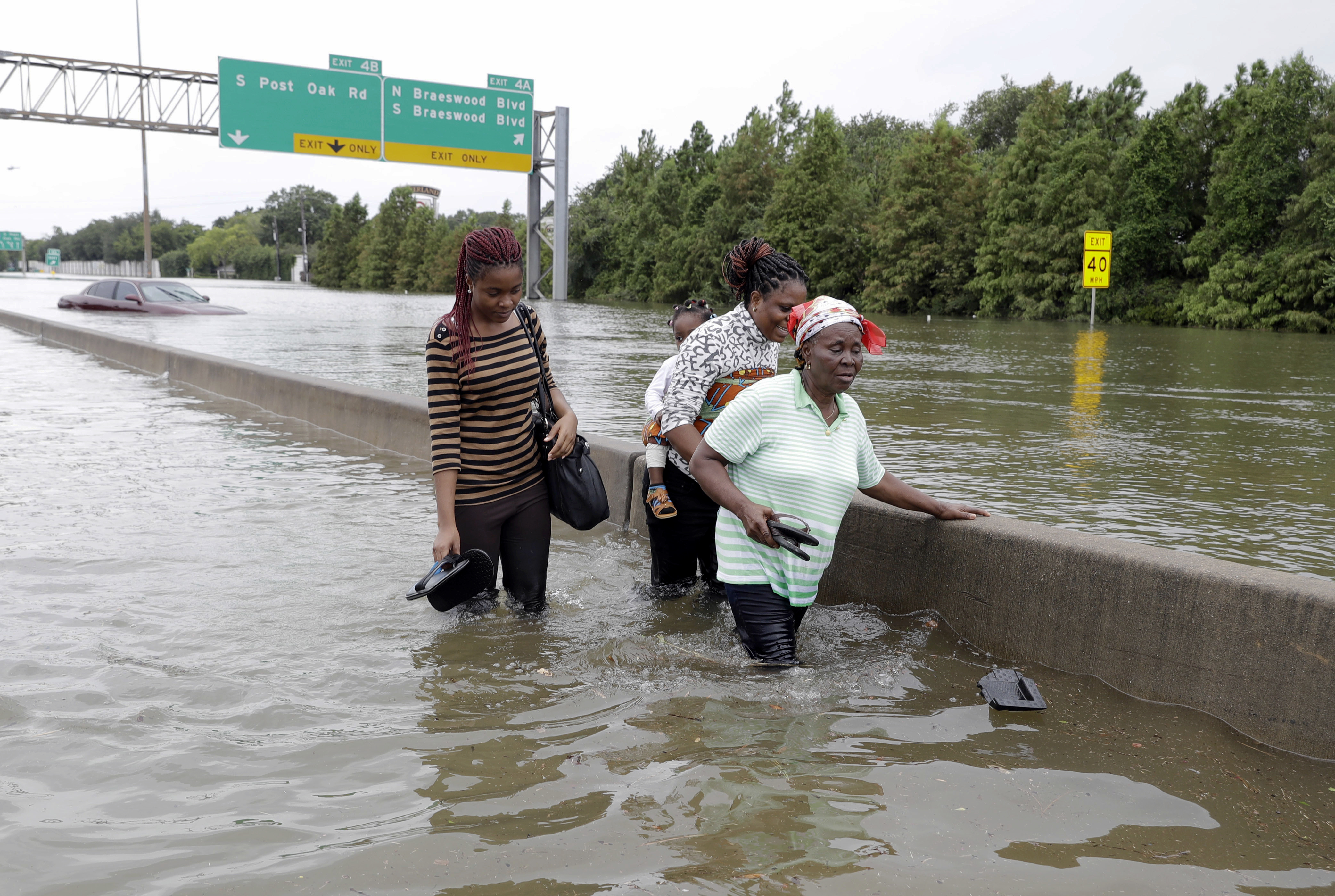 Evacuees wade down a flooded section of Interstate 610 as floodwaters from Tropical Storm Harvey rise Sunday, Aug. 27, 2017, in Houston. CREDIT: AP Photo/David J. Phillip
