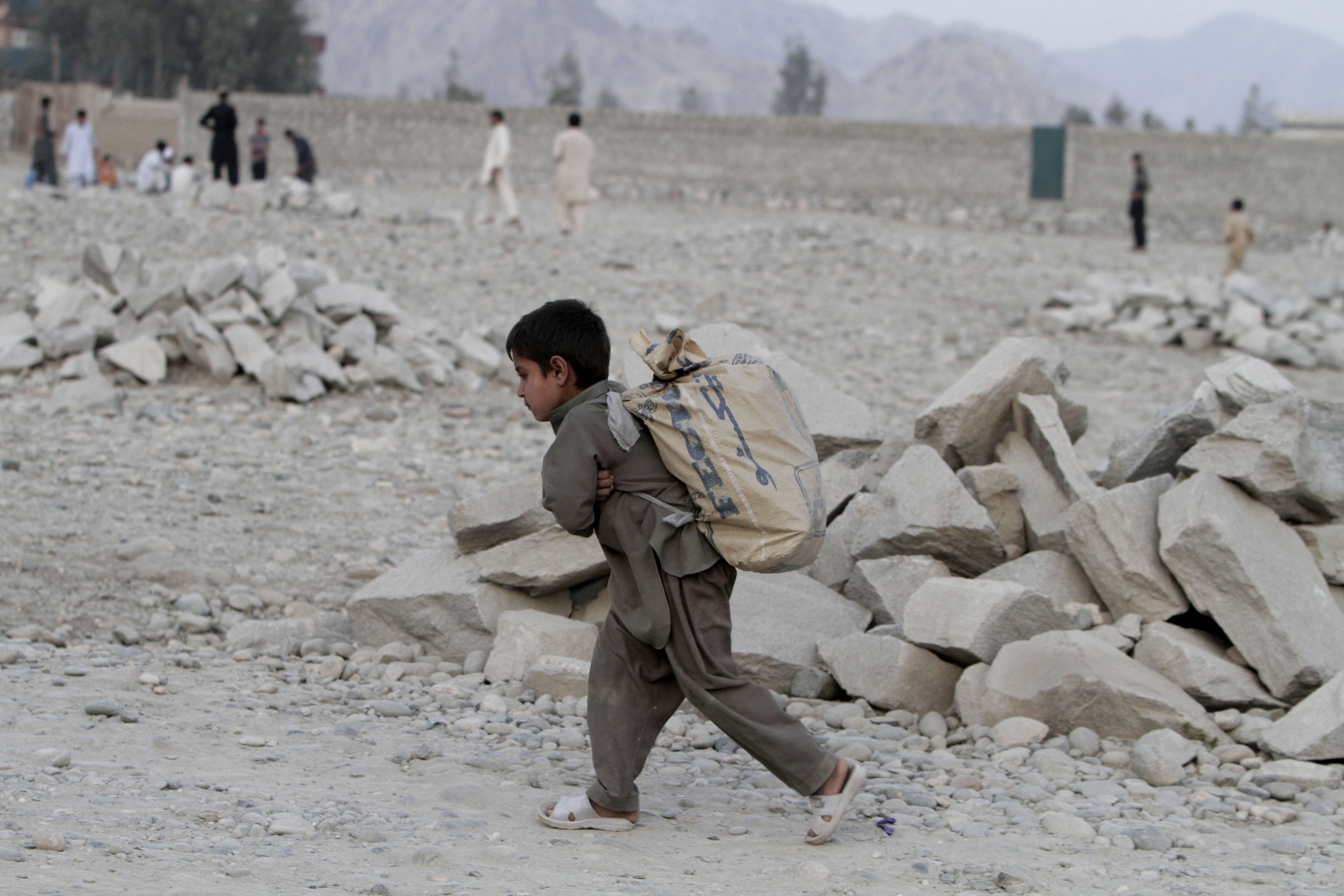 An Afghan boy, Ahmad Wali, 7, carries firewood in the Behsood district of Jalalabad, Afghanistan, Feb 18, 2013. CREDIT: AP Photo/Rahmat Gul