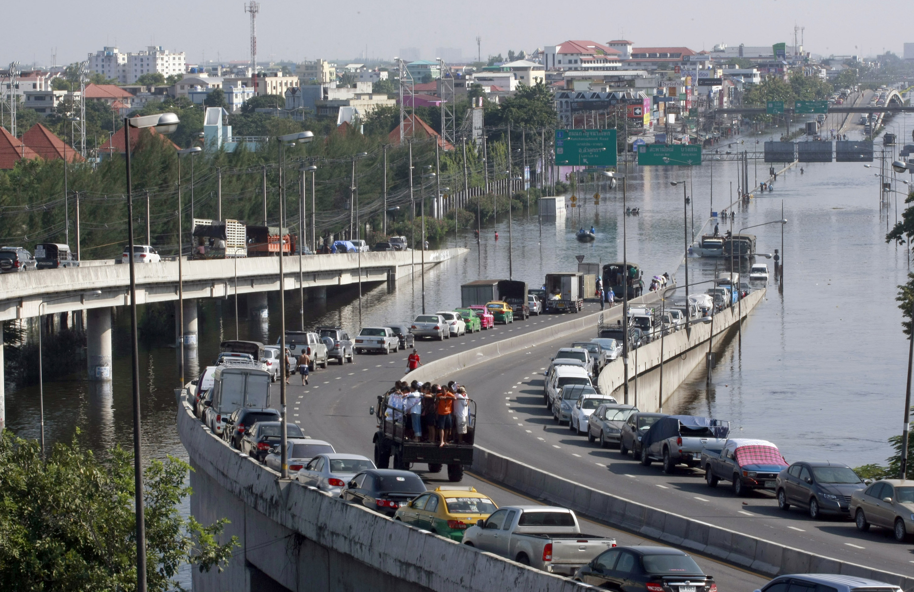 In this Oct. 24, 2011 file photo, cars are parked on an overfly on a flooded street in Bangkok, Thailand. Sea level rise projections show Bangkok could be at risk of inundation in 100 years unless preventive measures are taken. But when the capital and its outskirts were affected in 2011 by the worst flooding in half-a century, the immediate trigger was water run-off from northern provinces, where dams failed to contain unusually heavy rains. (AP Photo/Apichart Weerawong, File)