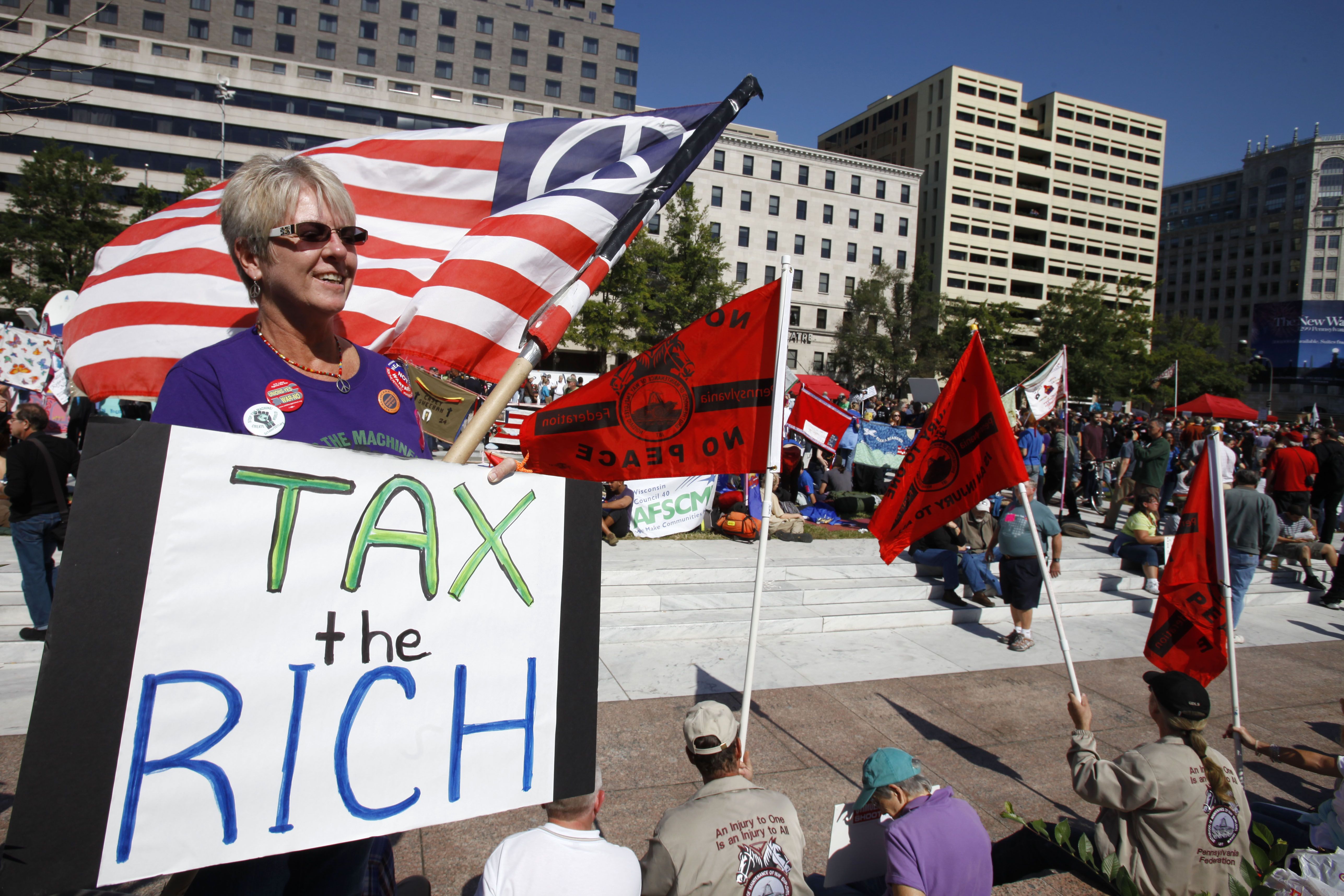In this Oct. 6, 2011 file photo, Carol Gay, of Brick, N.J., holds a sign saying "Tax the Rich," as several groups including the Peoples Uprisings, October 2011 Coalition, and Occupy DC, "occupy" Freedom Plaza in Washington. The income gap between the rich and everyone else is large and getting larger, while middle-class incomes stagnate. That's raised concerns that the nation's middle class isn't sharing in economic growth as it has in the past. And it sparked the Wall Street protests that spread to other cities in the country. (Credit: AP Photo/Jacquelyn Martin, File)