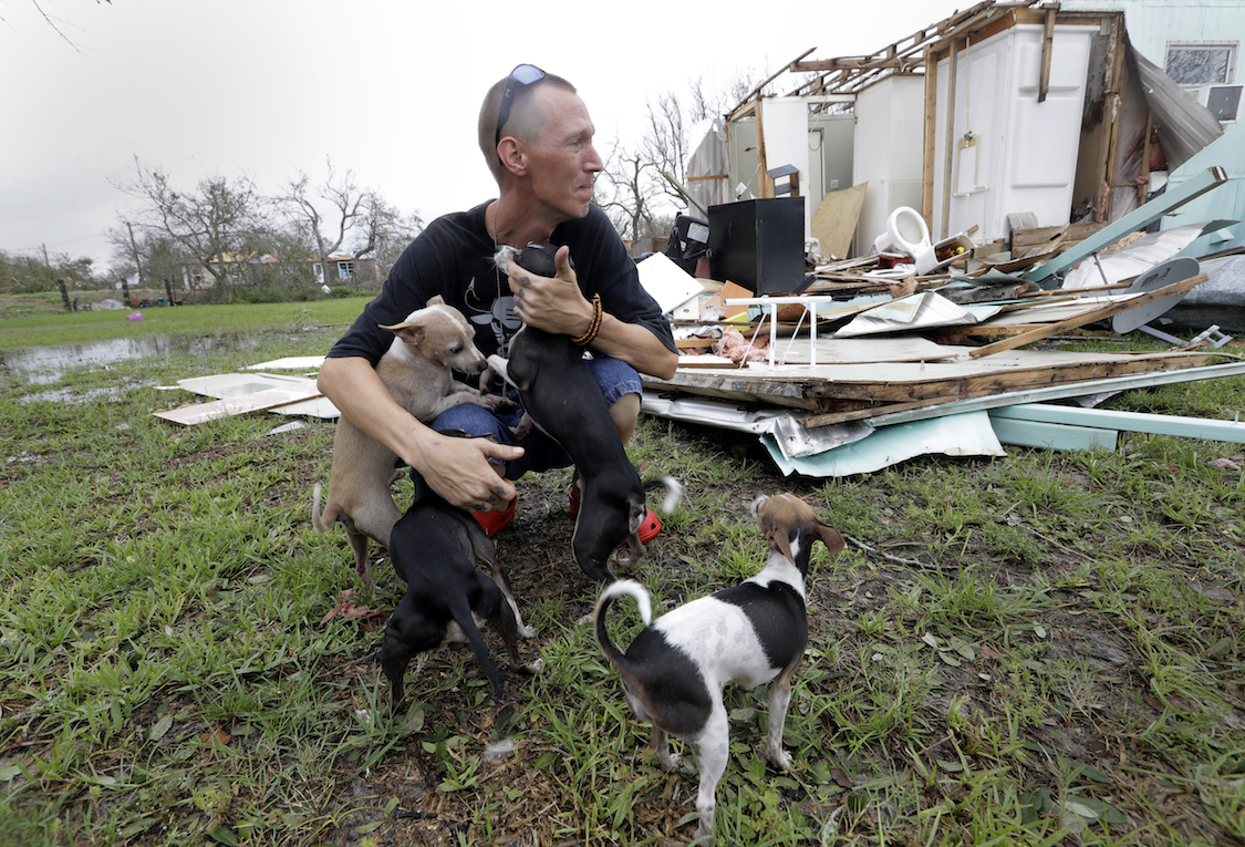 Sam Speights tries to hold back tears while holding his dogs and surveying the damage to his home in the wake of Hurricane Harvey, Sunday, Aug. 27, 2017, in Rockport, Texas. CREDIT: AP/Eric Gay