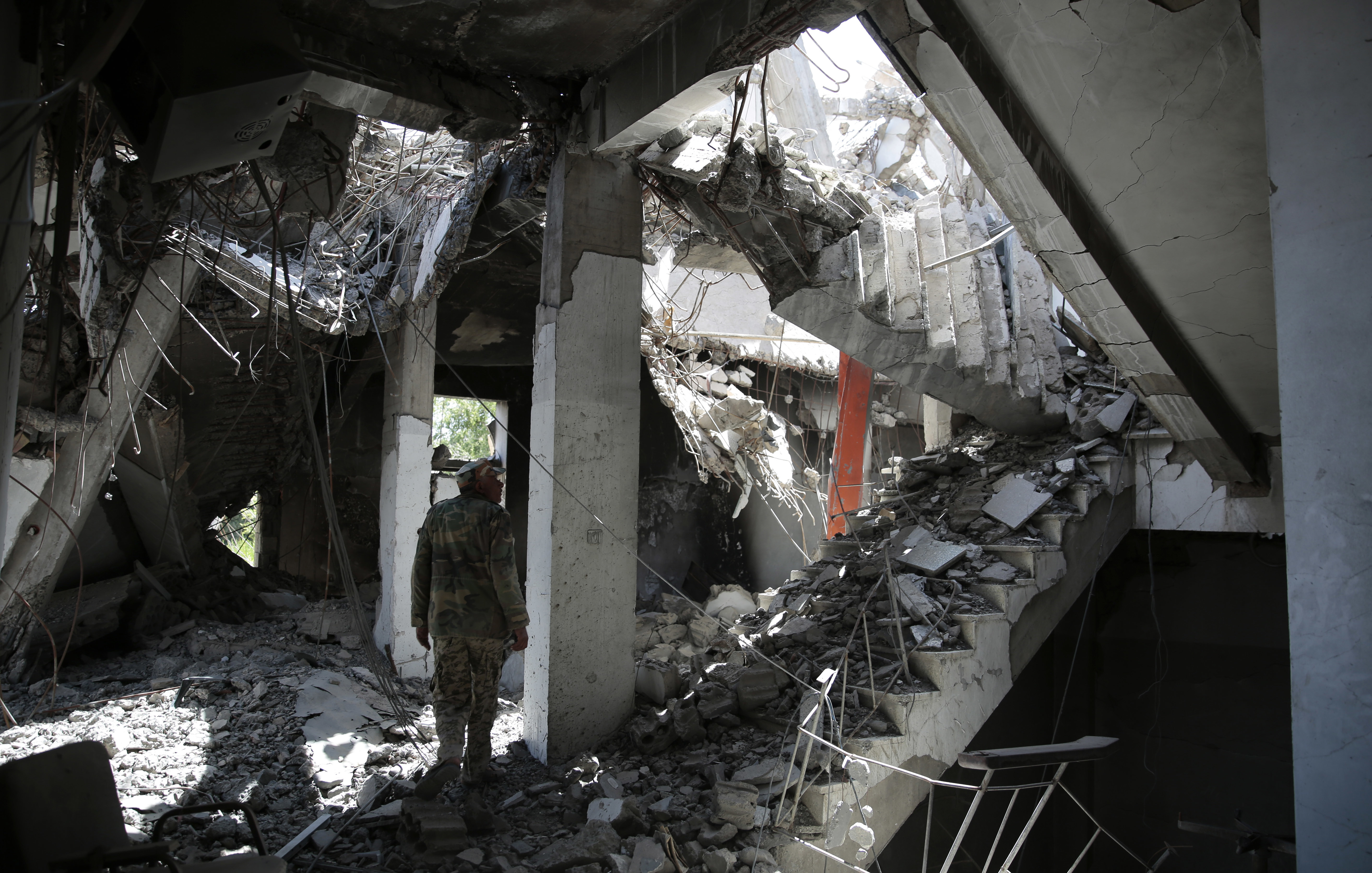 A Yemeni soldier walks amid the rubble of a Government compound building that was destroyed by Saudi-led airstrikes, in Saada province, Yemen. (CREDIT: Hani Mohammed/AP Photo)