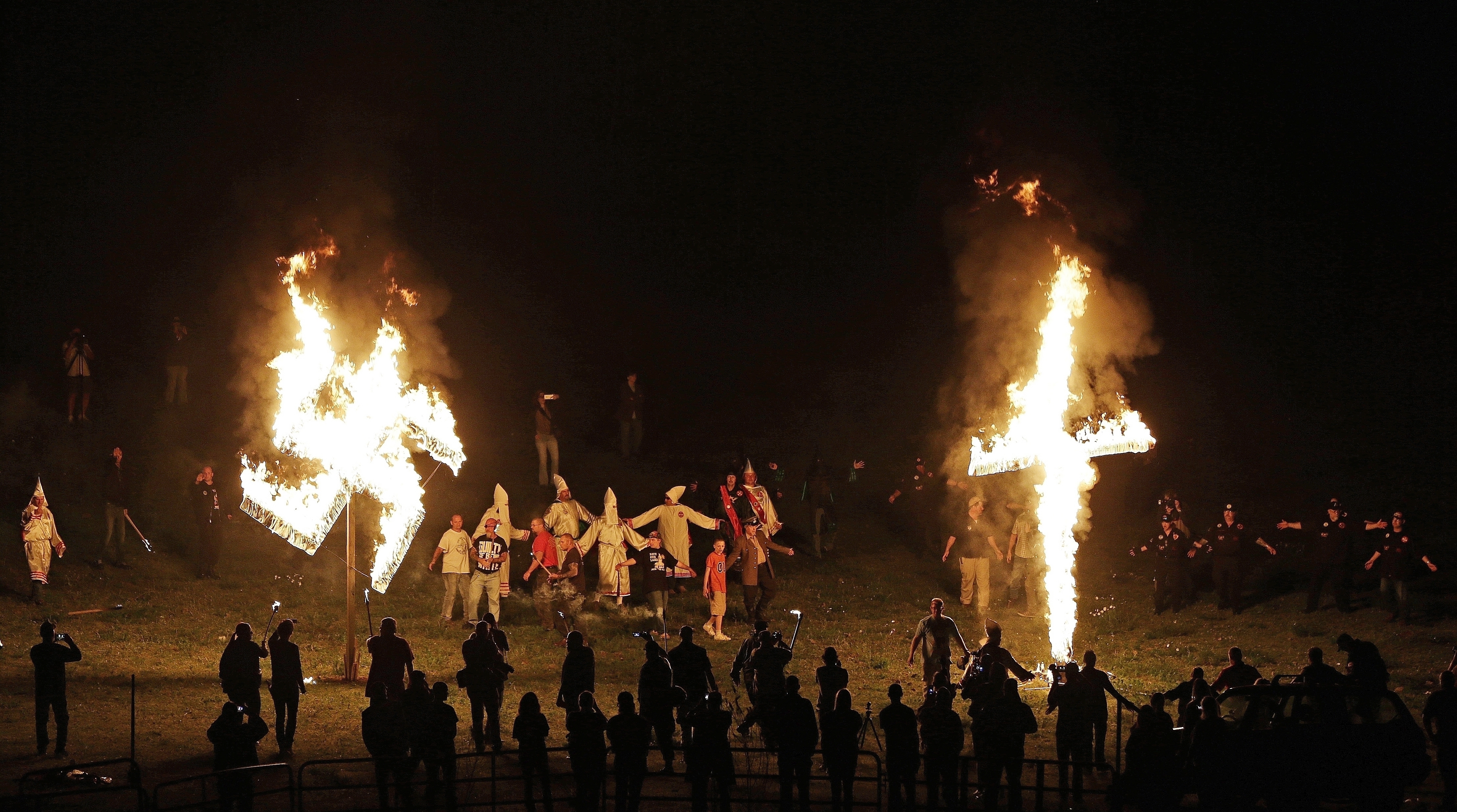 In this April 23, 2016 file photo, members of the Ku Klux Klan participate in cross and swastika burnings after a "white pride" rally in rural Paulding County near Cedar Town, Ga. CREDIT: AP Photo/Mike Stewart