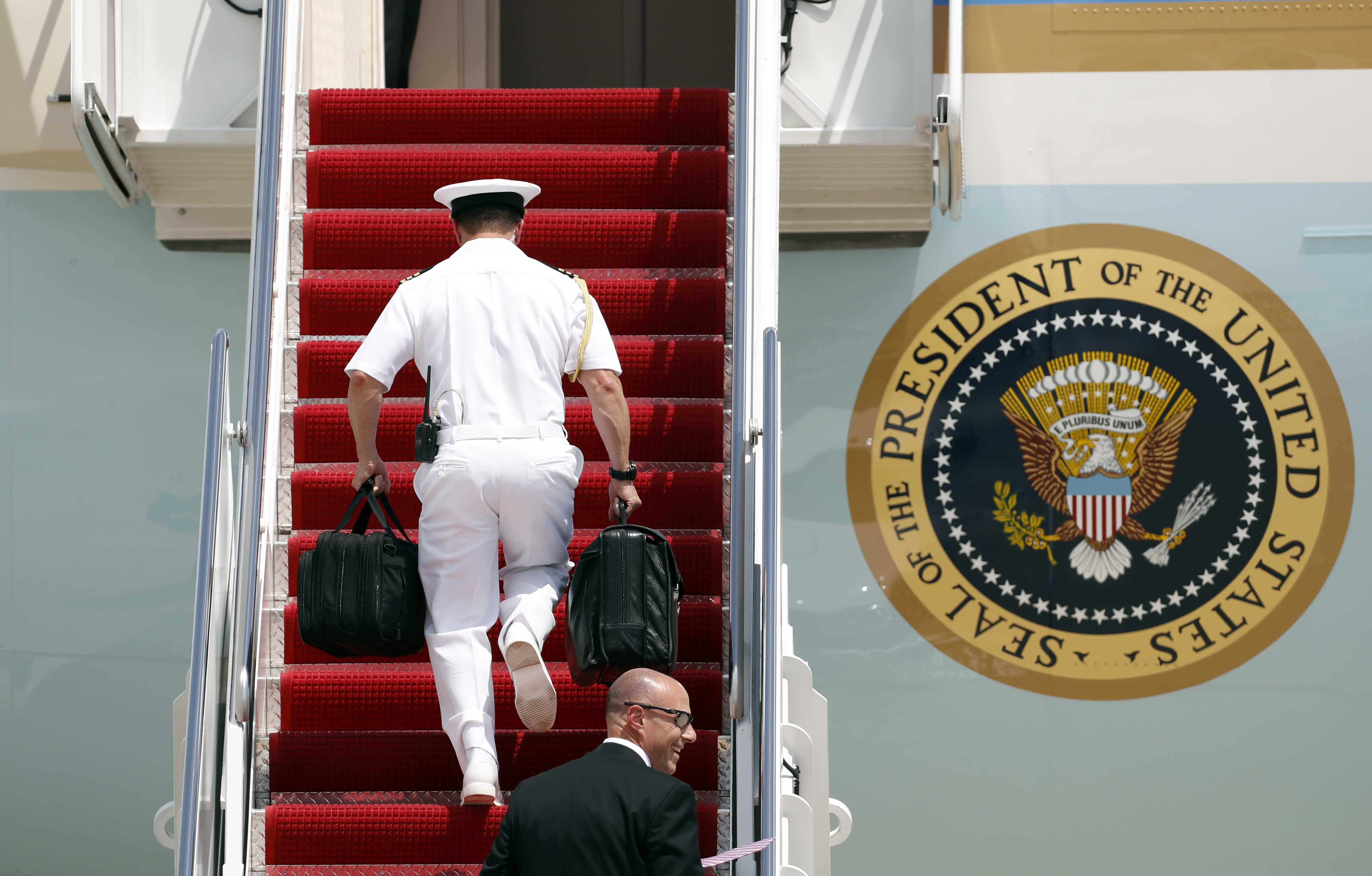 A U.S. Navy military aide carries the “president’s emergency satchel" also known as "the football," with nuclear launch codes, boards Air Force One at Andrews Air Force Base, Md., Friday, May 19, 2017. (Credit: AP Photo/Alex Brandon)