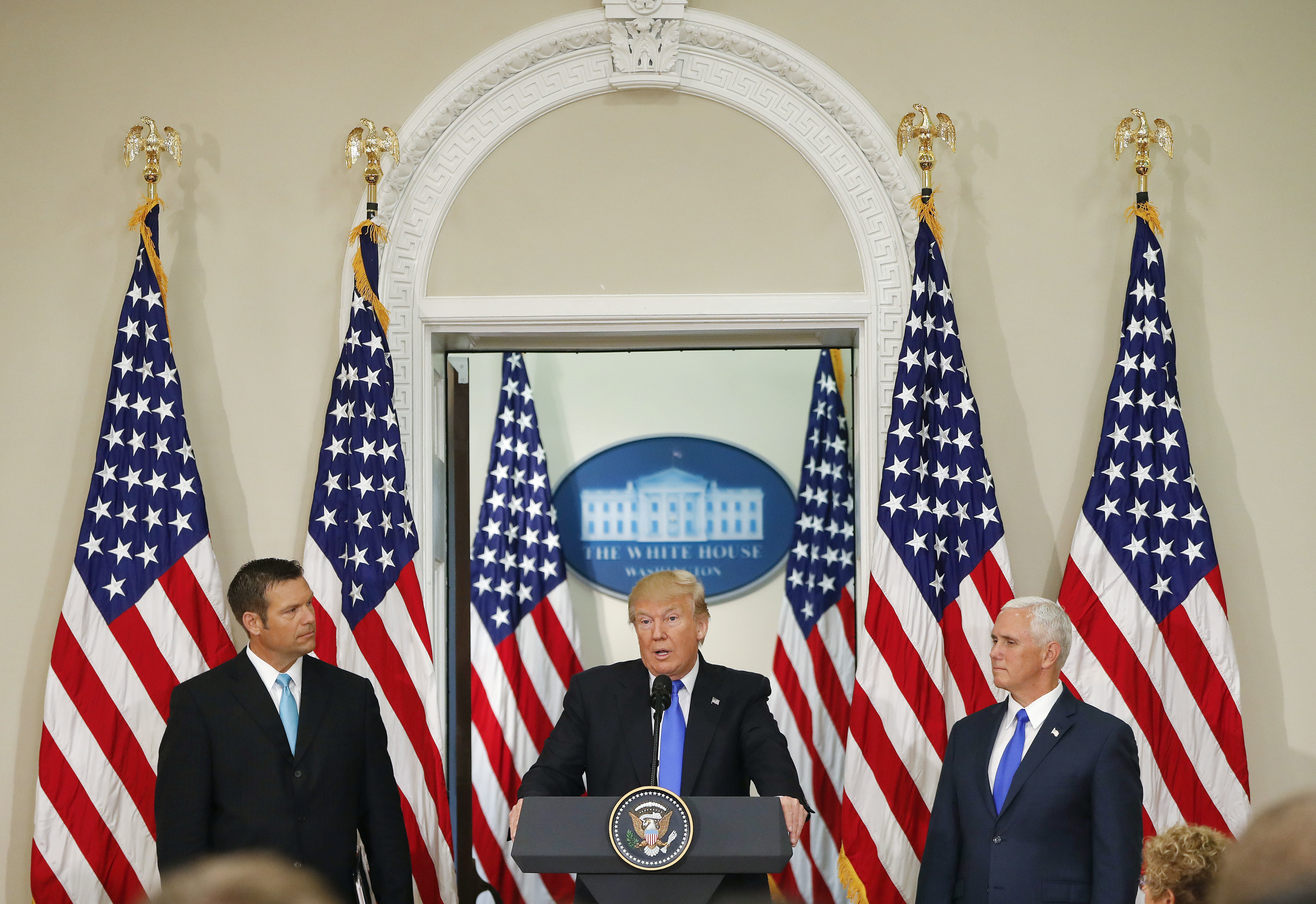 President Donald Trump, with Kansas Secretary of State Kris Kobach, left, and Vice President Mike Pence, right, speaks at a meeting of the Presidential Advisory Commission on Election Integrity, Wednesday, July 19, 2017, in the Eisenhower Executive Office Building on the White House complex in Washington. CREDIT: AP Photo/Pablo Martinez Monsivais