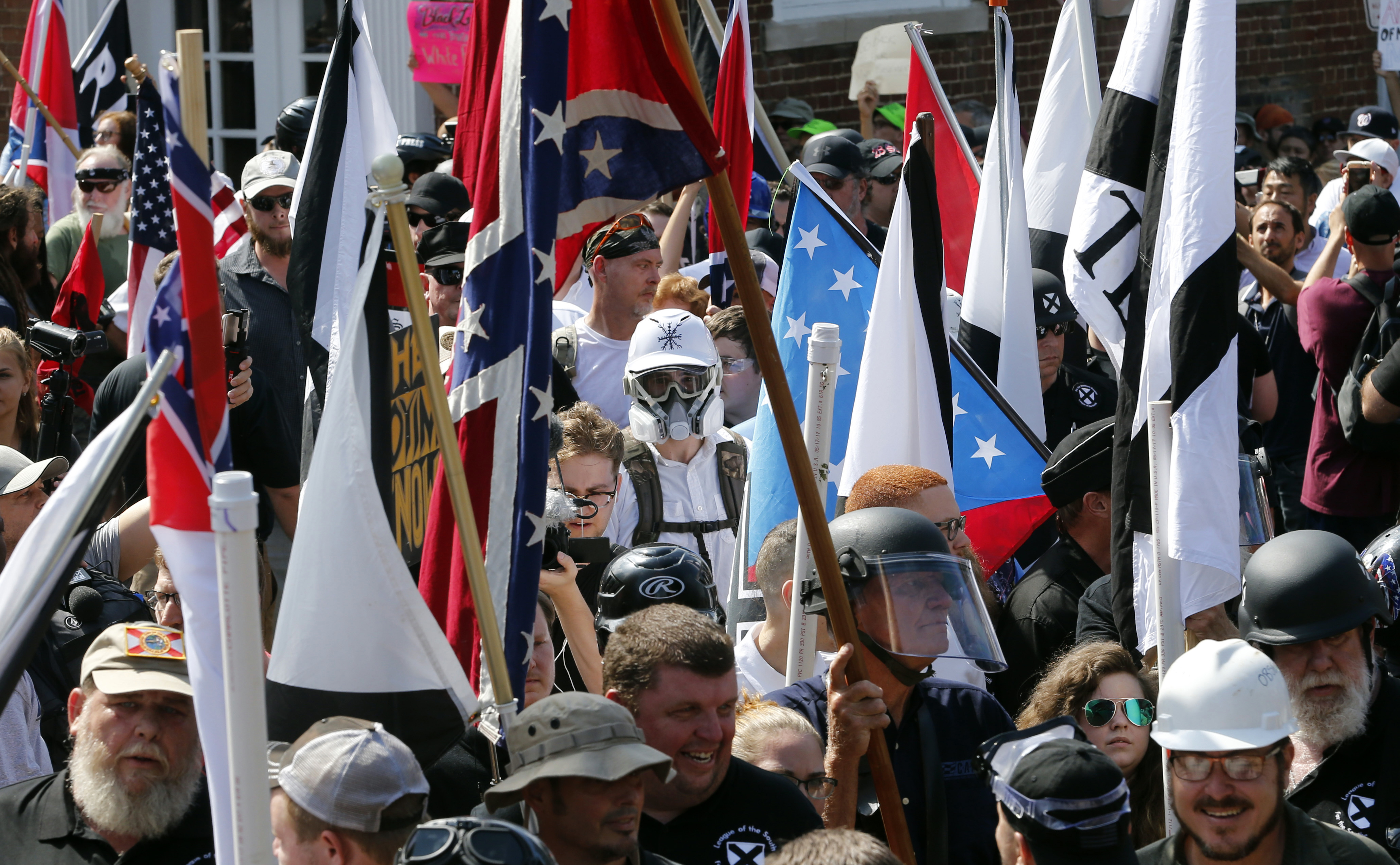 FILE - In this Saturday, Aug. 12, 2017 file photo, white nationalist demonstrators walk into the entrance of Lee Park surrounded by counter demonstrators in Charlottesville, Va. (AP Photo/Steve Helber)