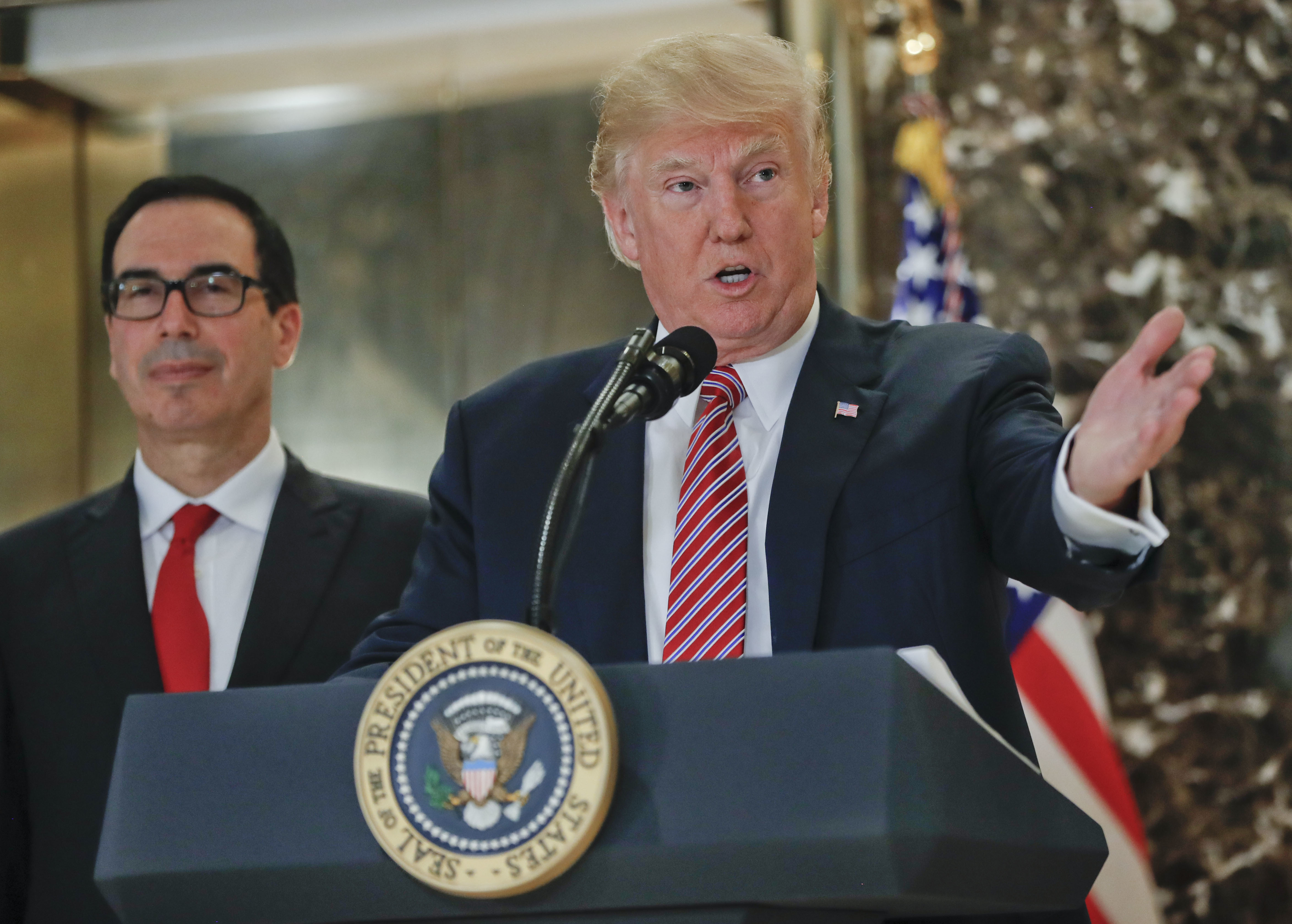President Donald Trump speaks to the media in the lobby of Trump Tower, Tuesday, Aug. 15, 2017 in New York. With Trump is Treasury Secretary Steve Mnuchin. (AP Photo/Pablo Martinez Monsivais)