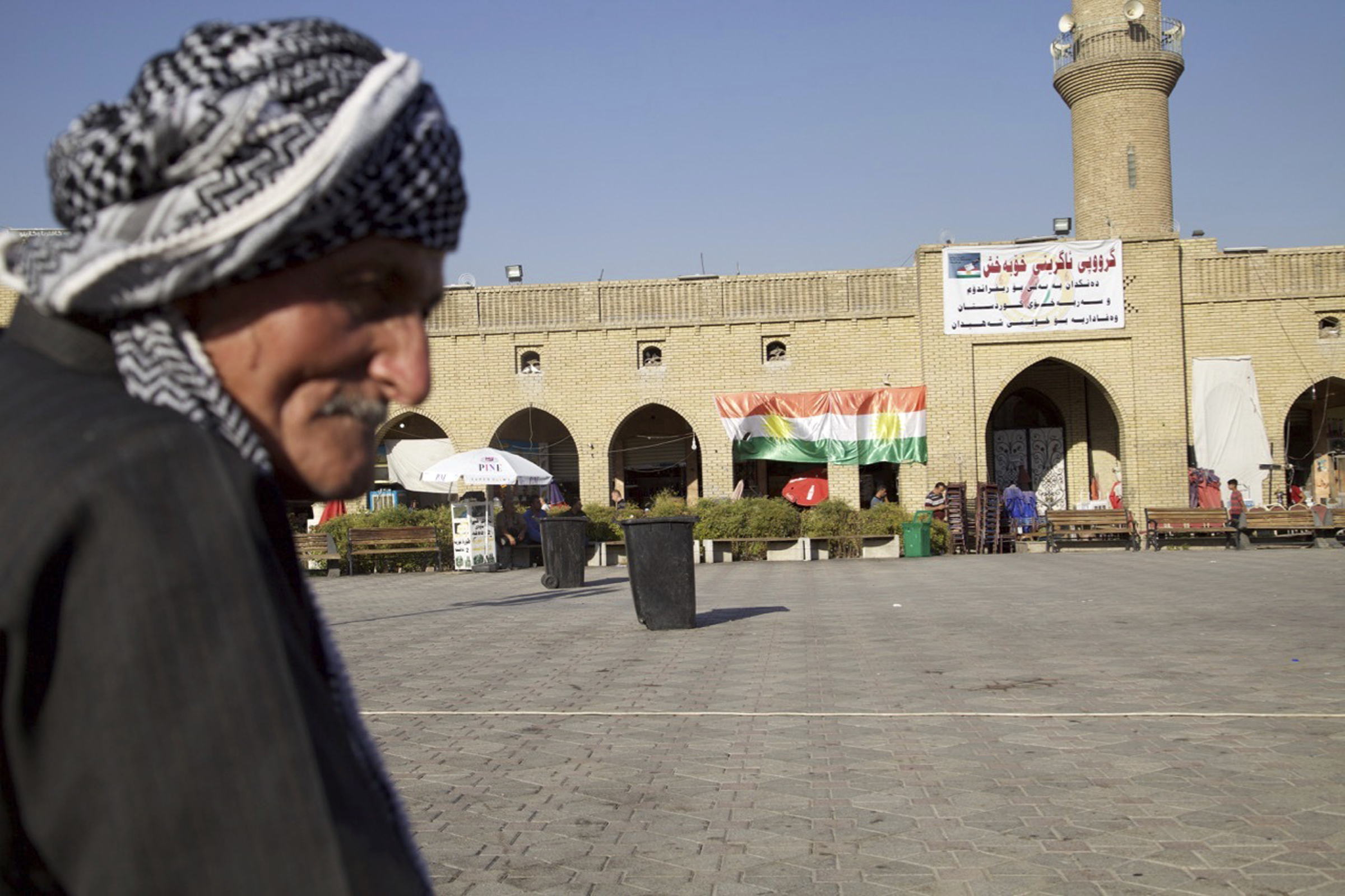 In this Thursday, Aug. 24, 2017 photo, an elderly man sits in the center of Irbil near a campaign poster urging people to vote yes in the upcoming poll on independence from Iraq. CREDIT: Balint Szlanko/AP Photo