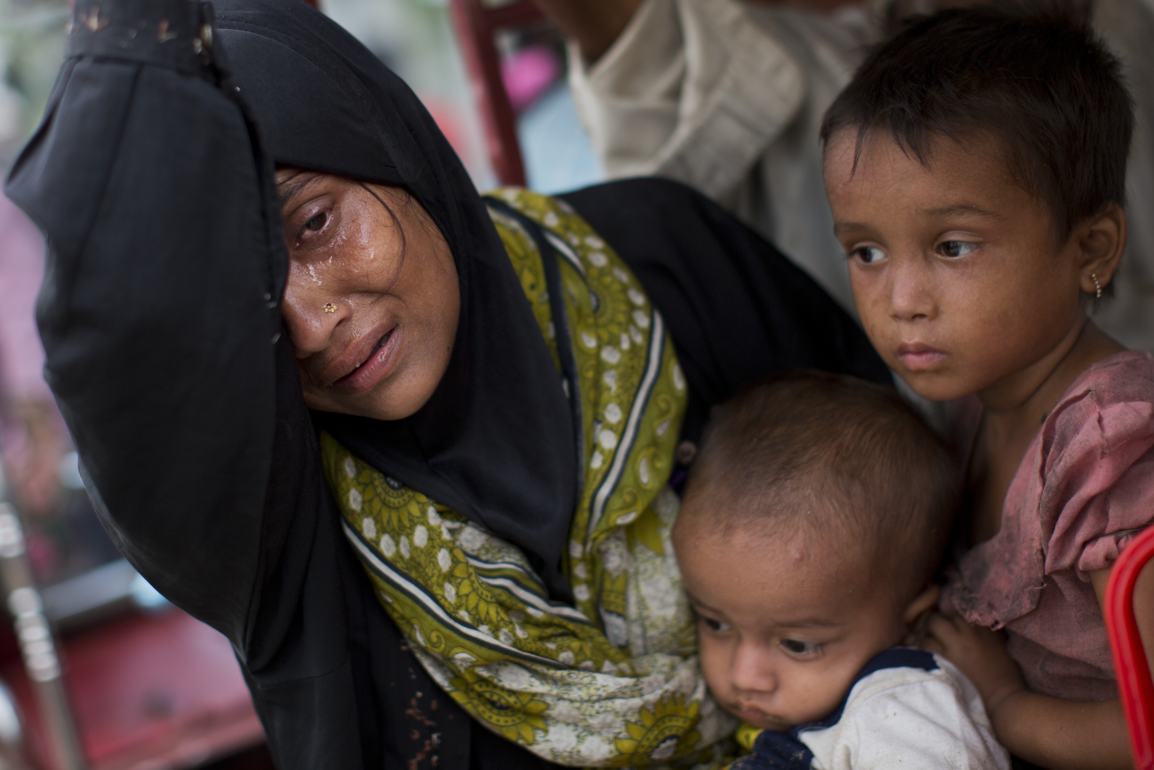 An exhausted Rohingya woman arrives with her children at Kutupalong refugee camp after crossing from Myanmmar to the Bangladesh side of the border, in Ukhia, Tuesday, Sept. 5, 2017. The family said they had lost several family members in Myanmar. Tens of thousands of Rohingya Muslims, fleeing the latest round of violence to engulf their homes in Myanmar, have been walking for days or handing over their meager savings to Burmese and Bangladeshi smugglers to escape what they describe as certain death. (AP Photo/Bernat Armangue)