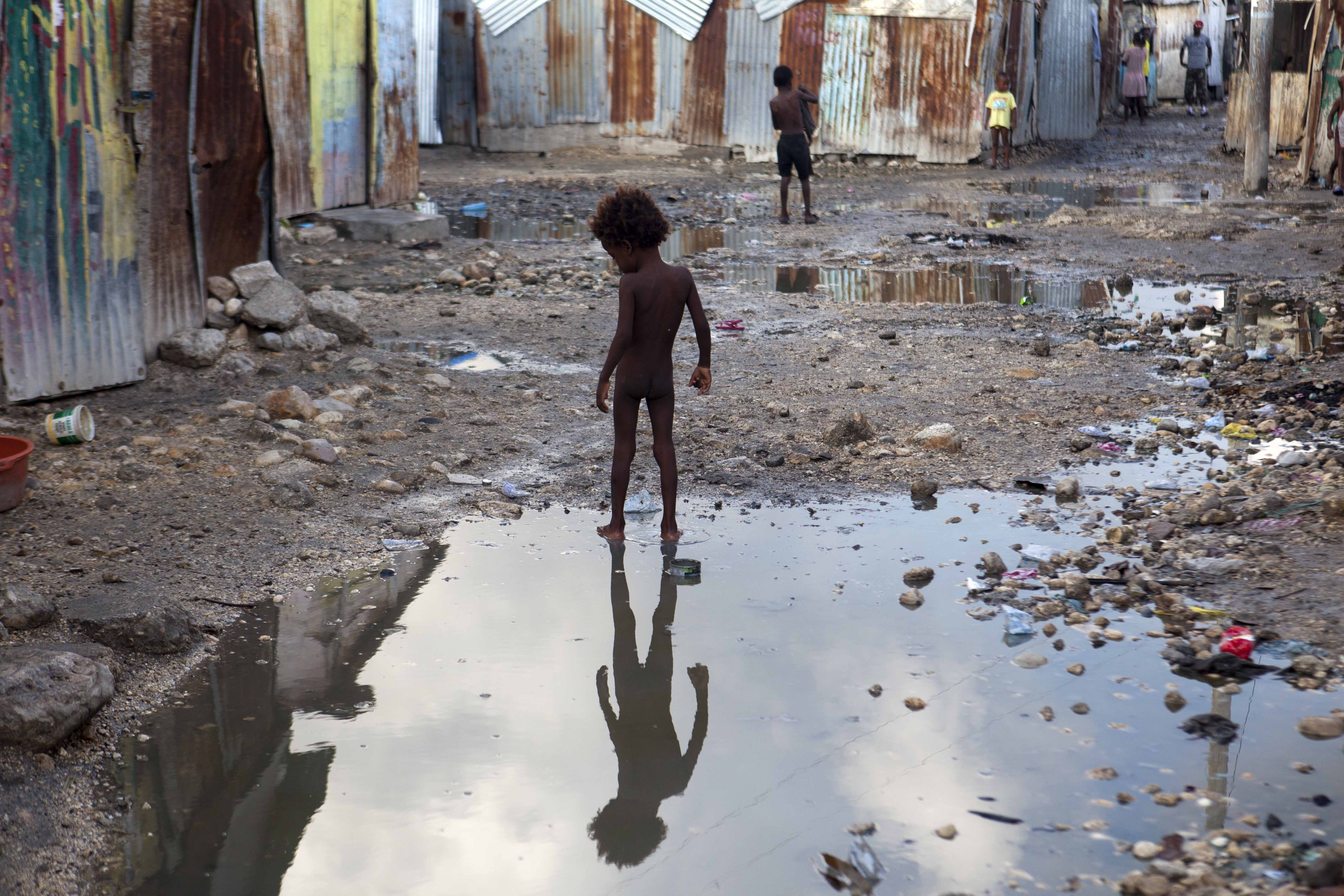 A child plays in a puddle in the seaside slum of Port-au-Prince, Haiti, Wednesday, Sept. 6, 2017. CREDIT: AP Photo/Dieu Nalio Chery