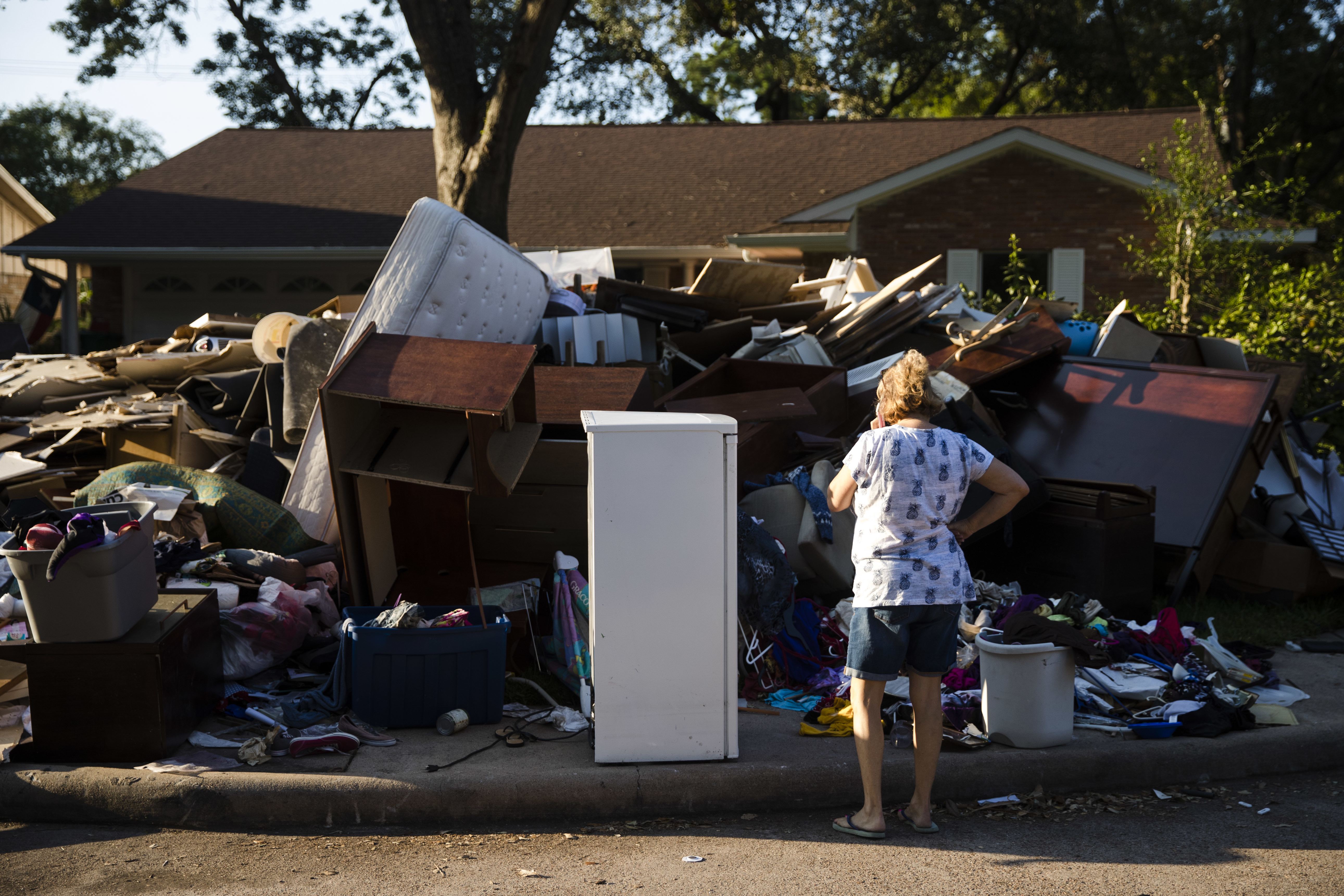 Tamlyn Lima views debris piled in front of her home in the aftermath of Hurricane Harvey on Wednesday, Sept. 6, 2017, in Houston. CREDIT: AP Photo/Matt Rourke