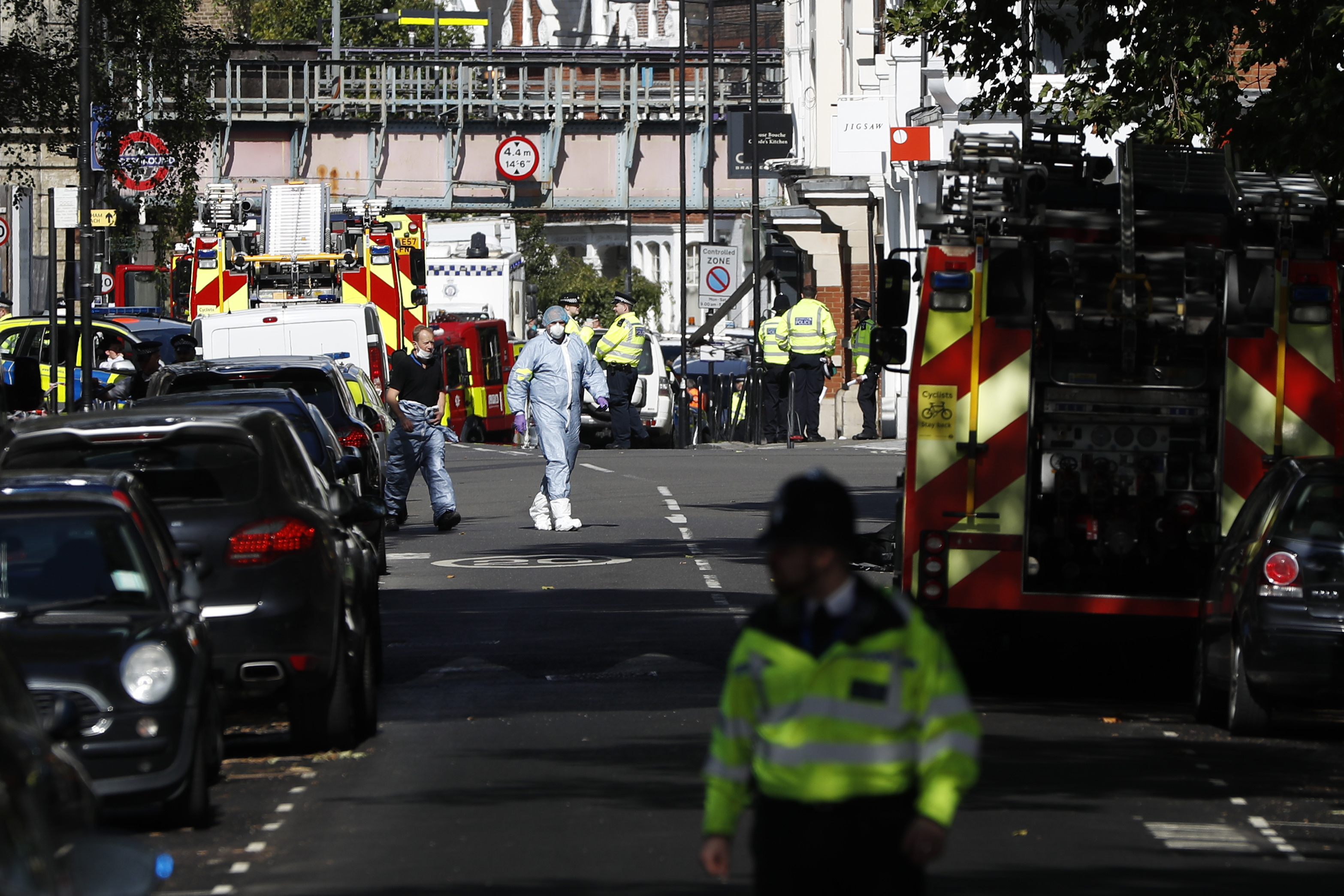 Police forensic officers walk within a cordon near where an incident happened, that police say they are investigating as a terrorist attack, at Parsons Green subway station in London, Friday, Sept. 15, 2017. A bucket wrapped in an insulated bag caught fire on a packed London subway train Friday, sending commuters stampeding in panic at the height of the morning rush hour. (AP Photo/Kirsty Wigglesworth)